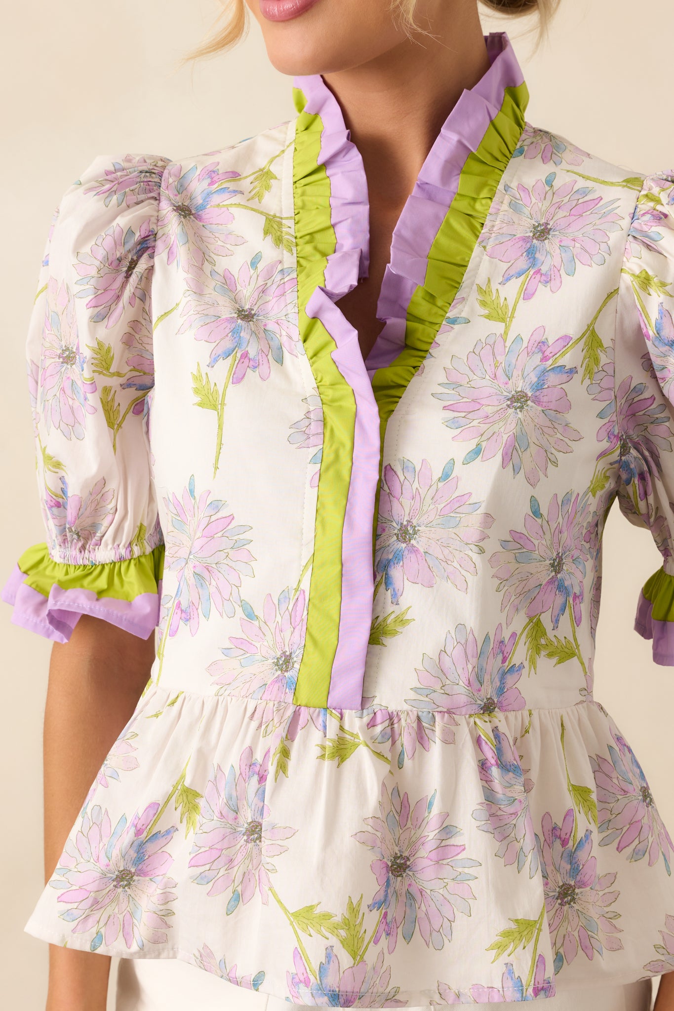 Close-up of the floral print and bright green ruffle trim along the neckline, showing fabric quality and embroidery detail.