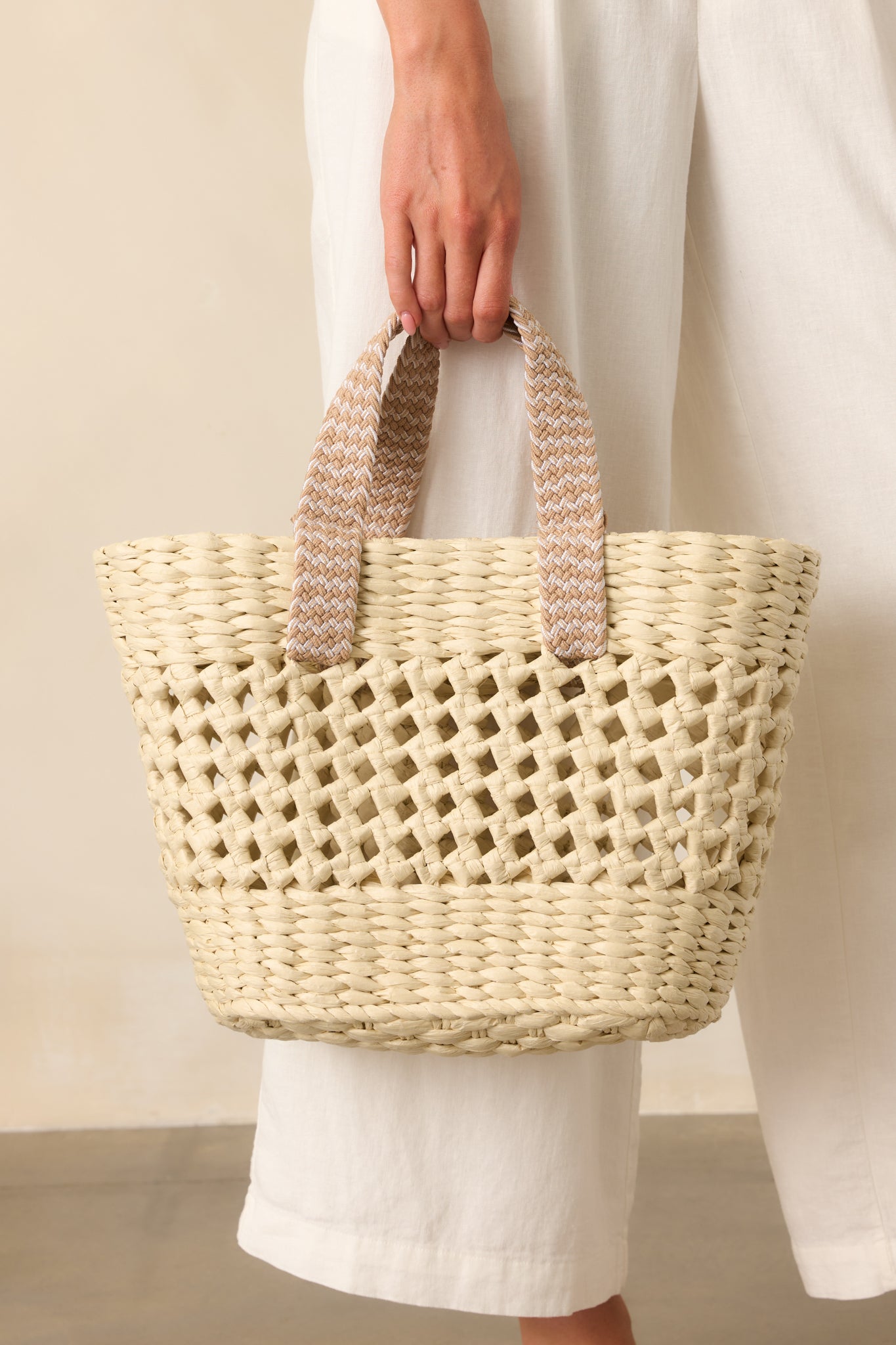 Cropped image focusing on the open weave middle panel and the texture contrast between the structured base and woven straw.