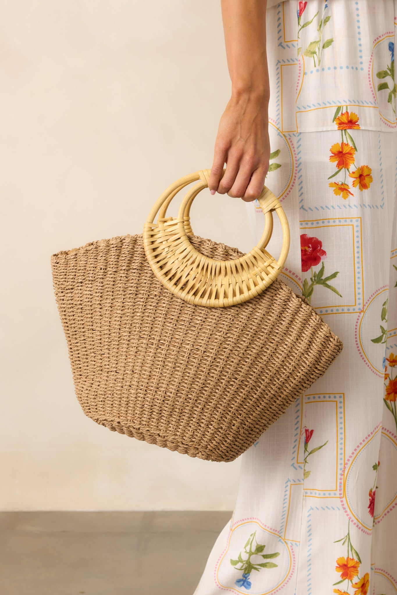 A cropped view highlighting the textured raffia woven fabric and the smooth finish of the natural bamboo handles.