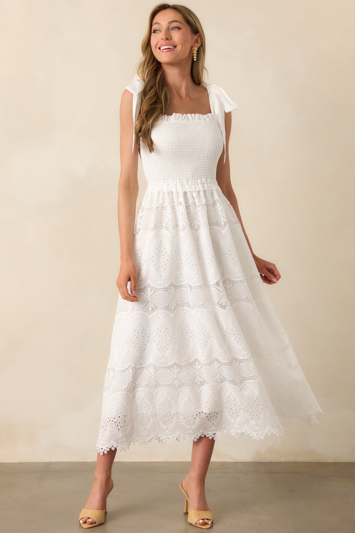 White maxi dress with a square neckline and smocked bust, shown in a full body front view to highlight its flowy silhouette.