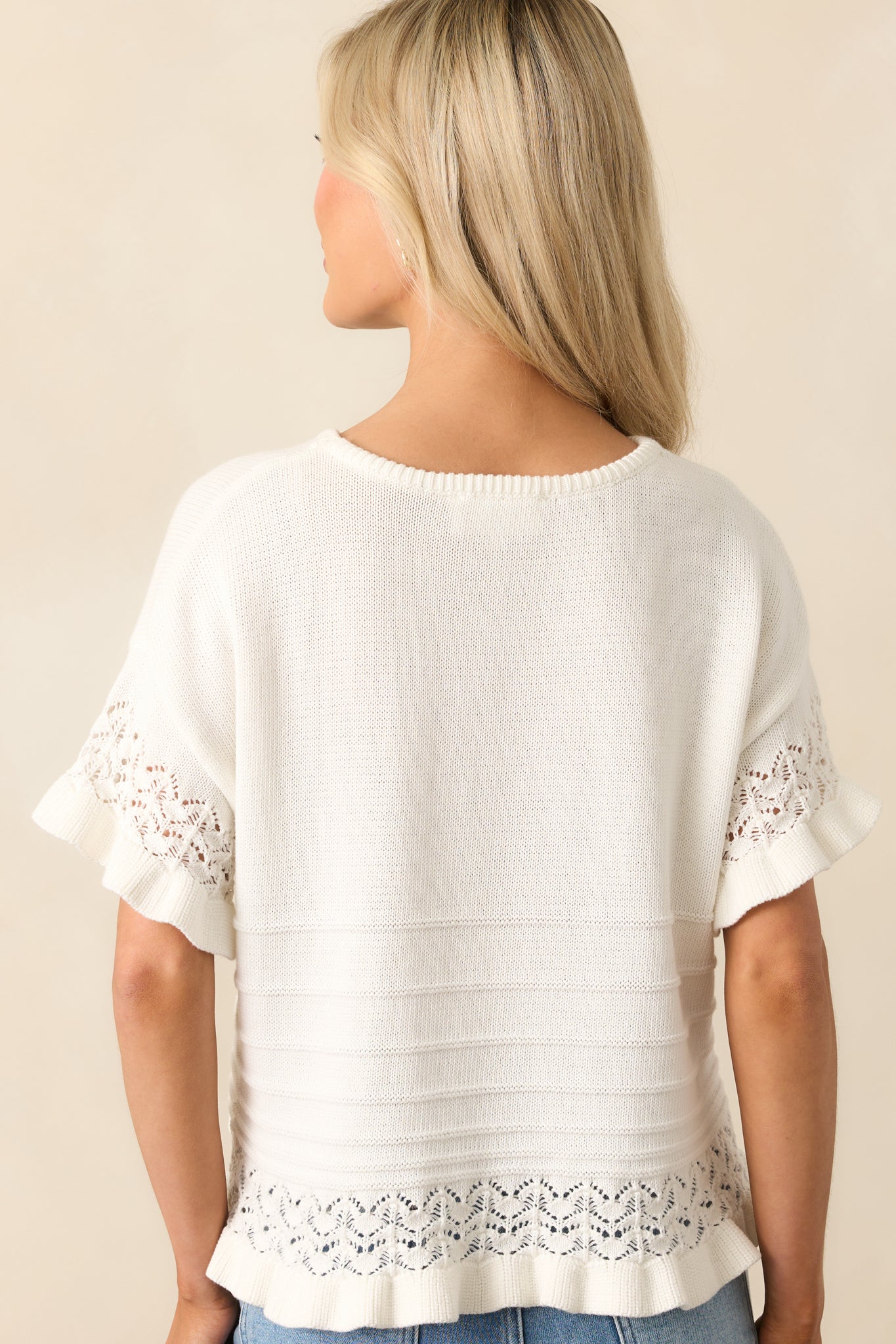 A view from behind of the ivory top, revealing its textured stripe design and relaxed fit through the shoulders and hem.