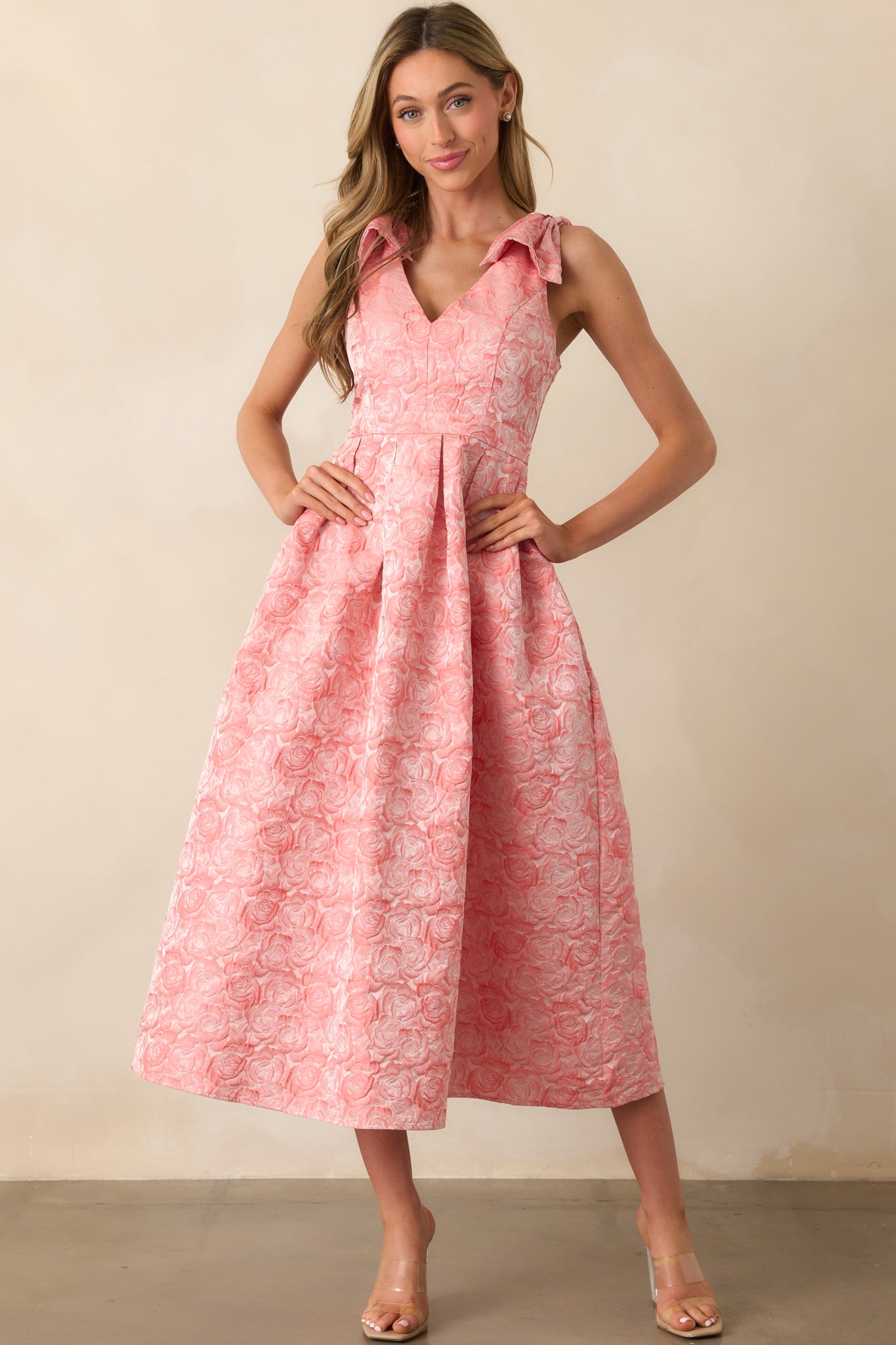 Pink coral dress with a fitted top and relaxed skirt, complete with subtle stitching and pocket placement.