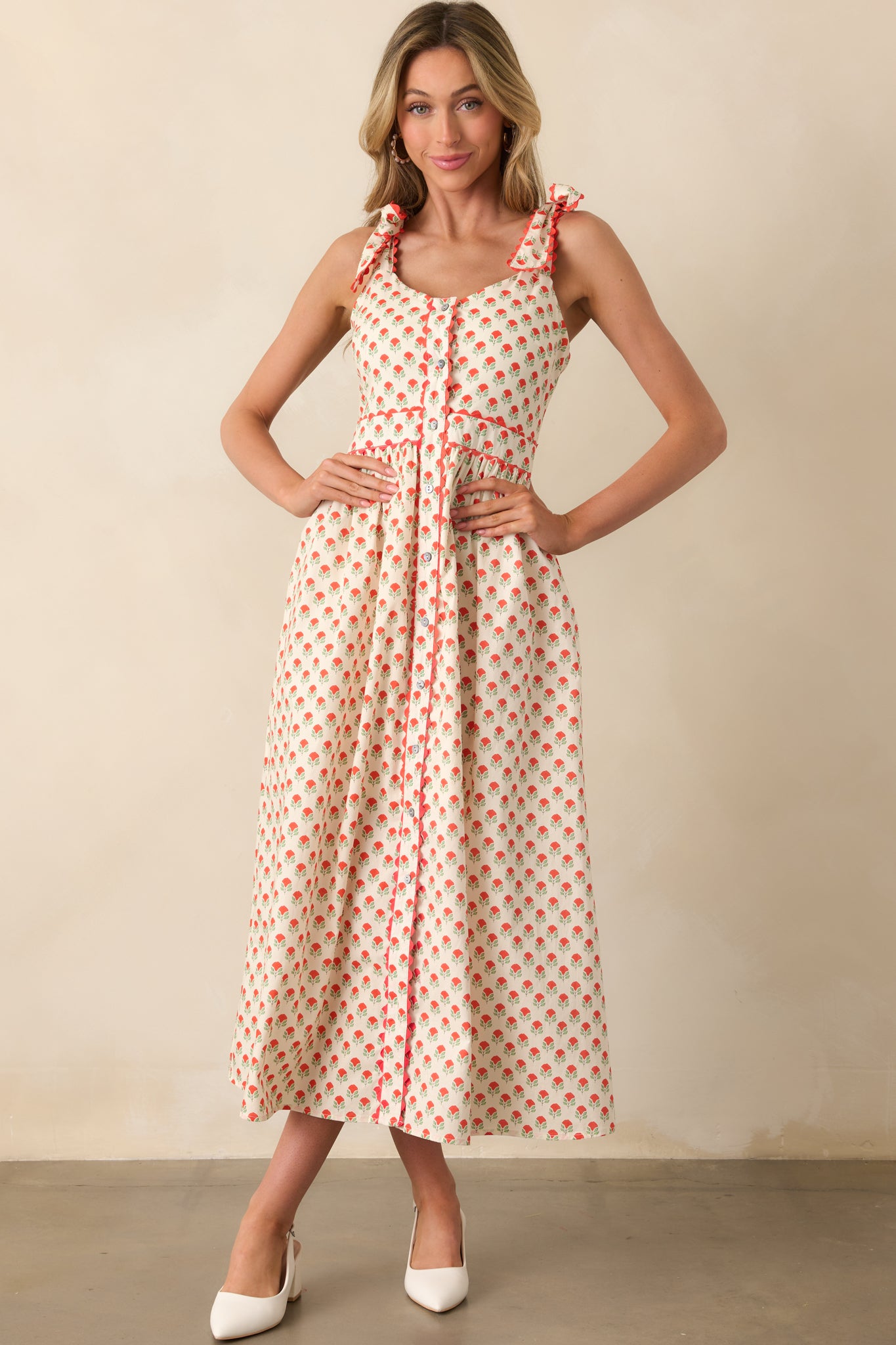 Front-facing image of a red floral maxi dress highlighting the structured scoop neckline and overall fit.