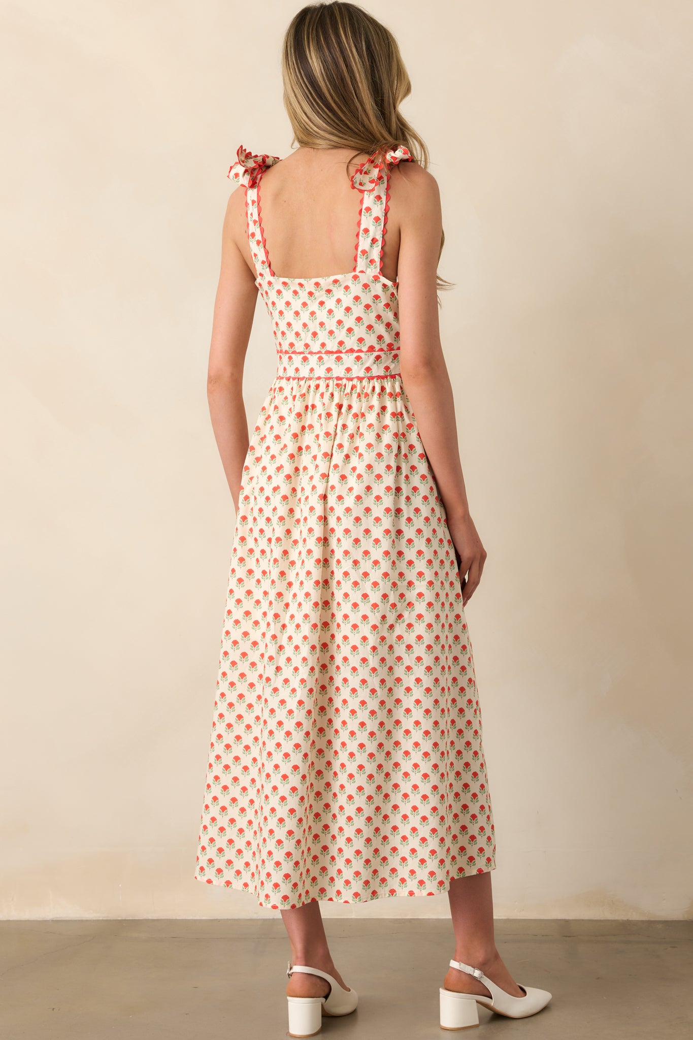 View from behind of the red floral maxi dress, showing the bow-tied straps and the continuation of the floral print.