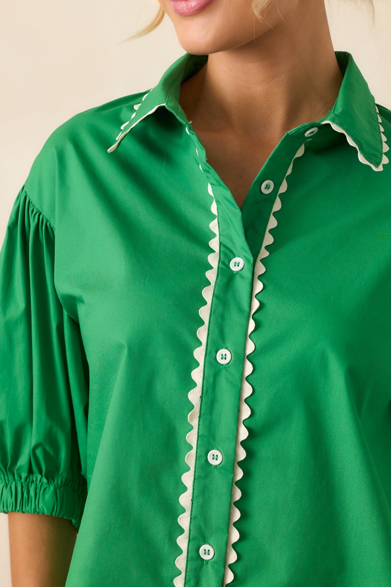 Detailed close-up of the white ric rac trim stitched onto the green fabric, showing fine texture and stitching