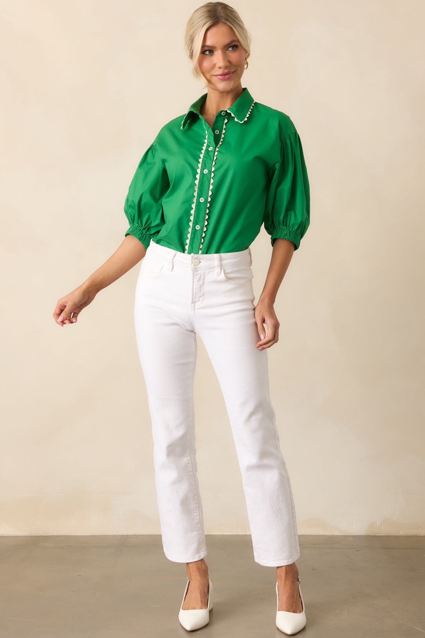 Front view of a green top featuring a collared neckline, functional button front, and relaxed fit.