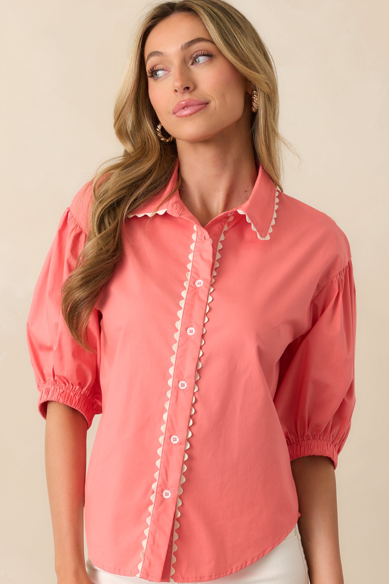 Close-up of the collared neckline and button-front closure on the pink coral top with ric rac trim.