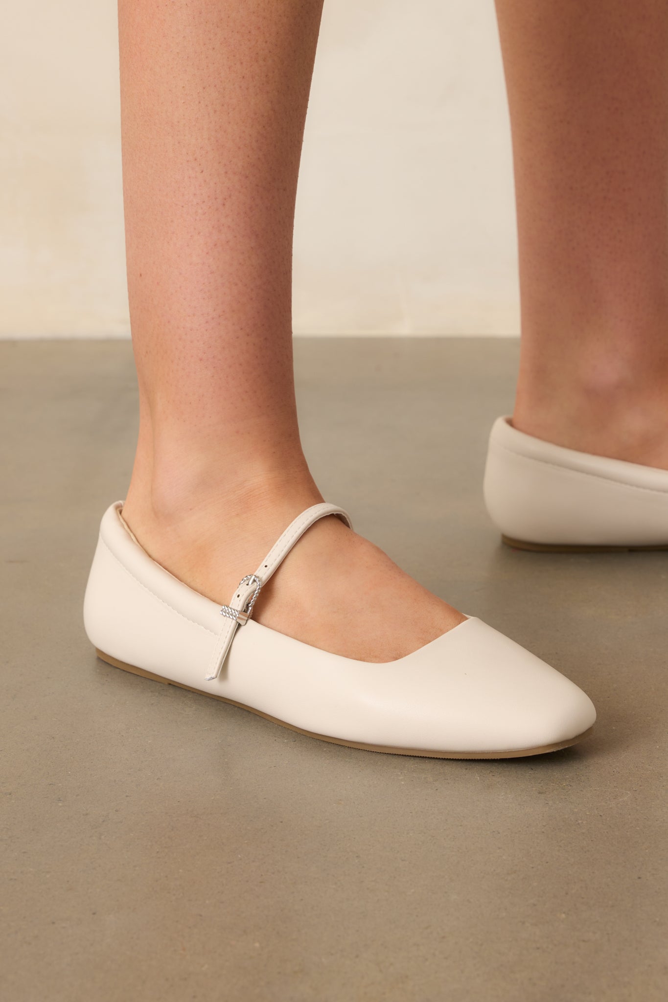An angled side shot of the ivory flats highlighting the stitching and material on the side and emphasizing craftsmanship.