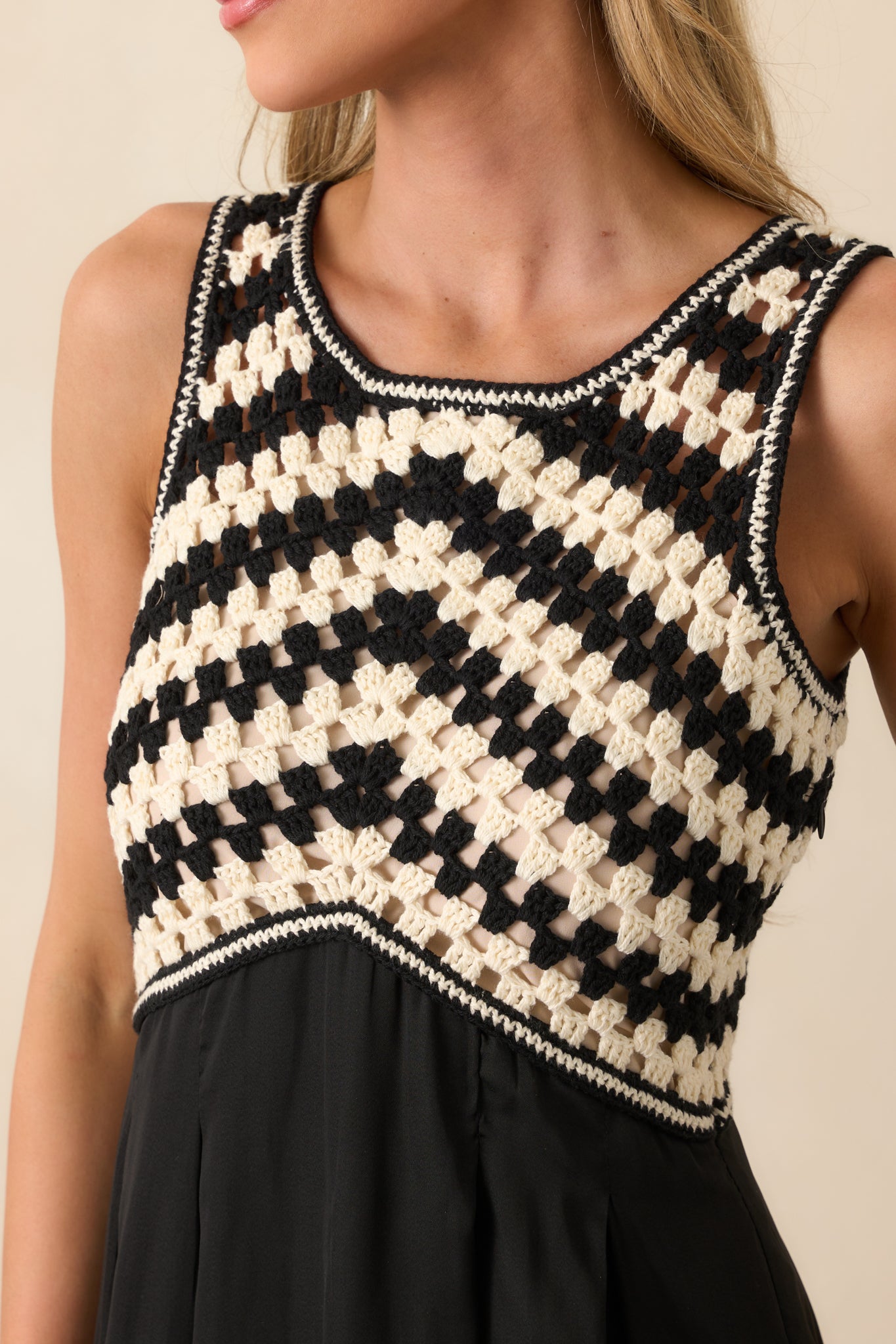 Close-up of black and white diagonal open knit bust with beige lining and round neckline detail.