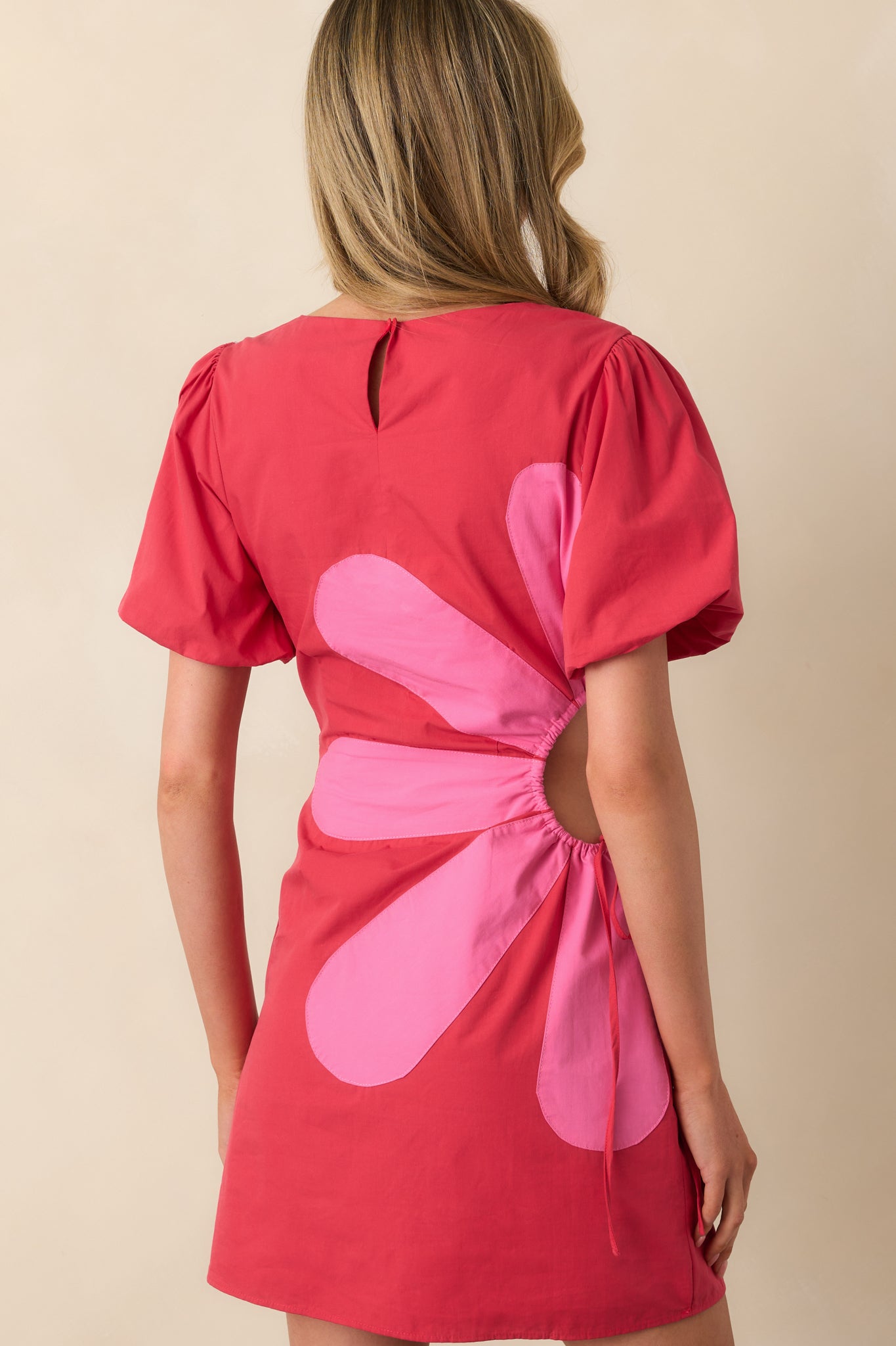 A view from behind of the mini dress, highlighting the keyhole closure at the neckline and clean lines of the back panel.