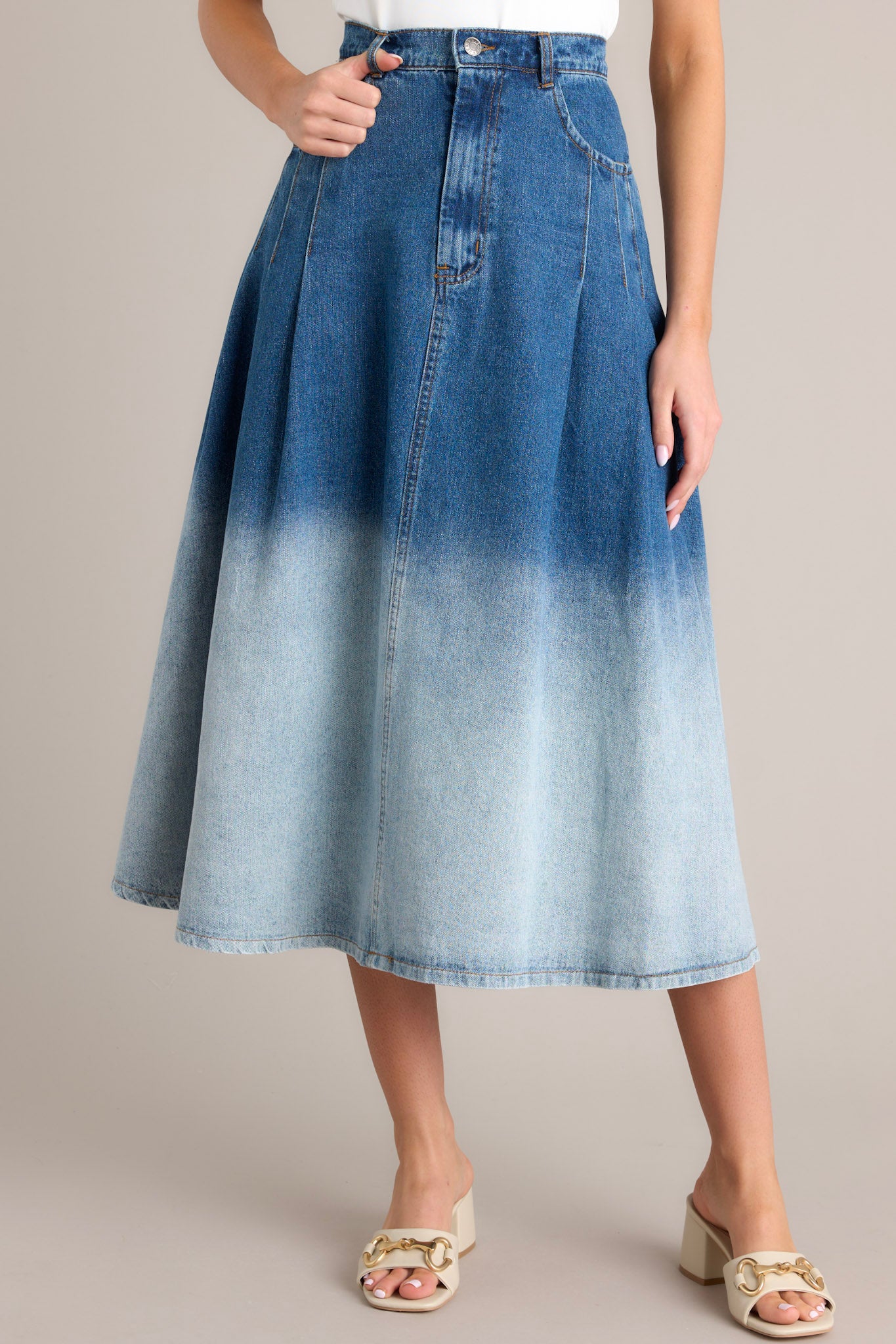 This skirt features a high waisted design, a classic button & zipper closure, belt loops, functional front pockets, subtle pleats, and an ombré gradient.