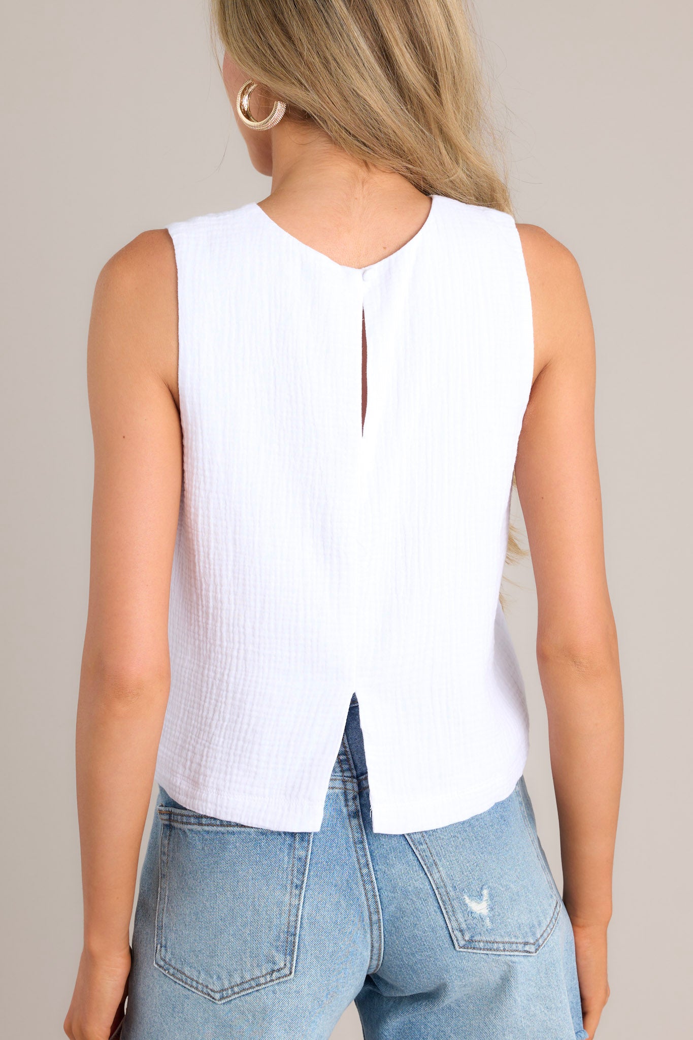 Back view of this top that features a crew neckline, a keyhole cutout with a functional button, and a back slit.