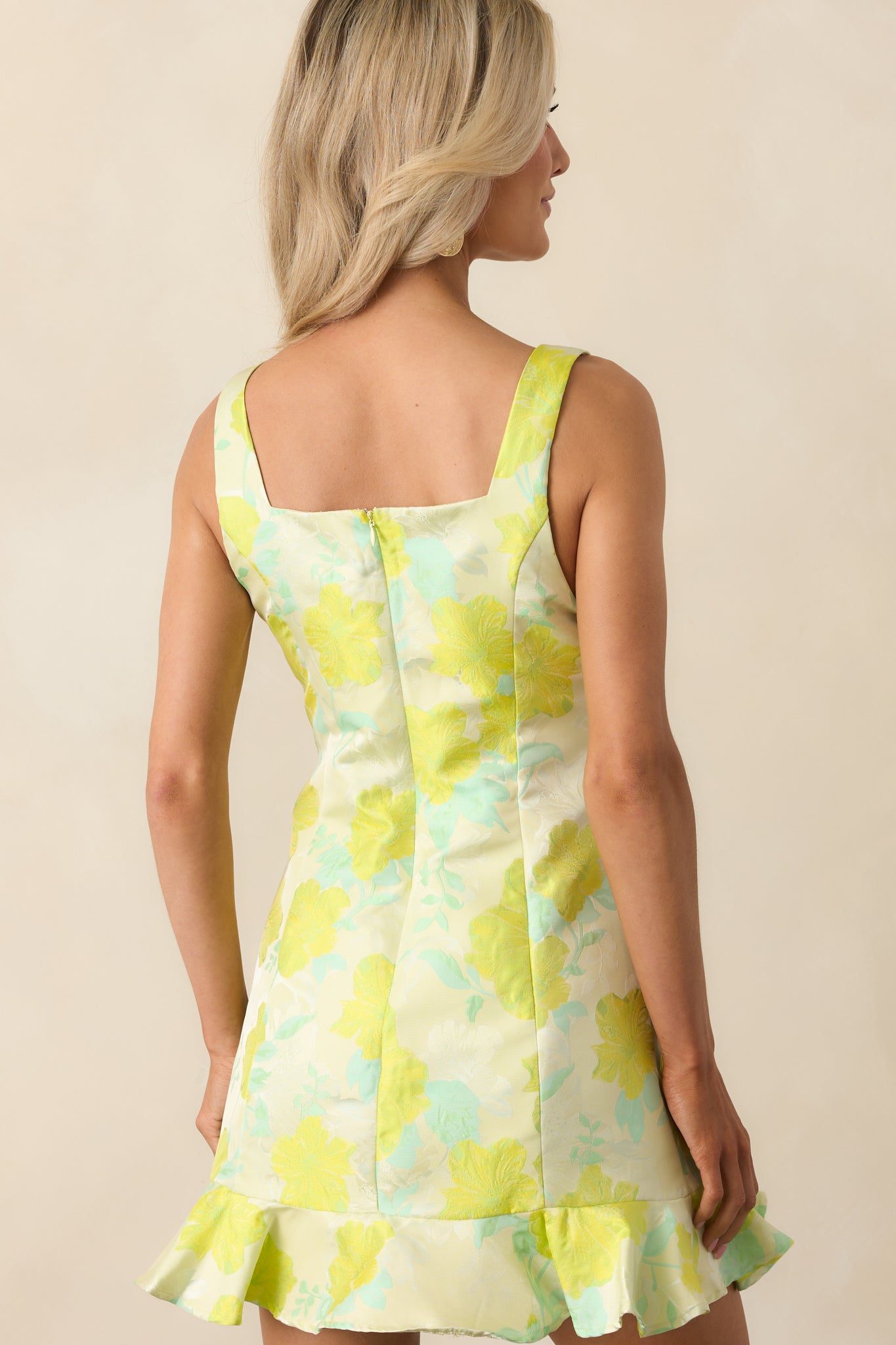 A view from behind of the yellow green mini dress showing the discrete zipper and smooth tailored fit.