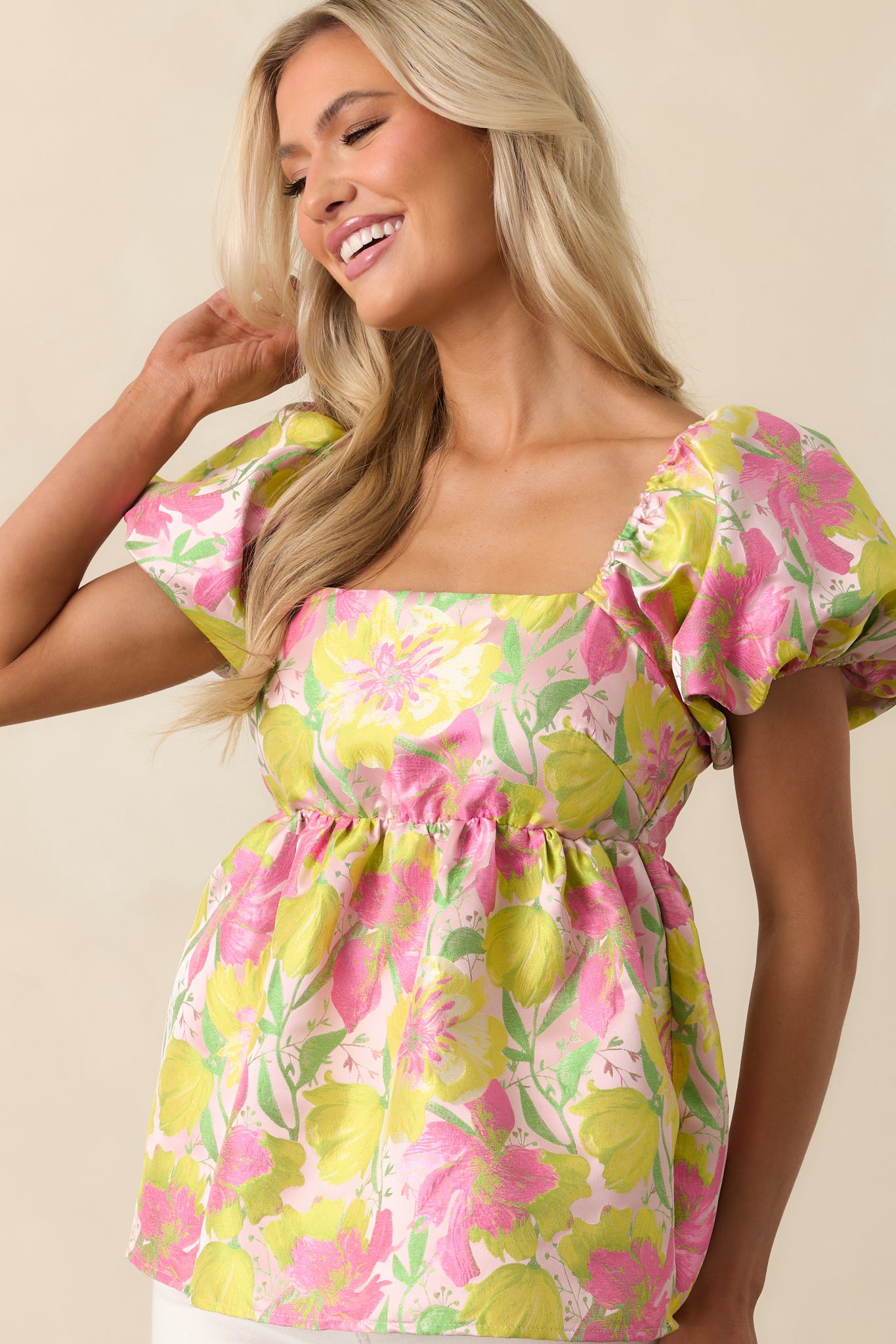 Cropped view showing the start of the peplum flare and bright floral pattern.