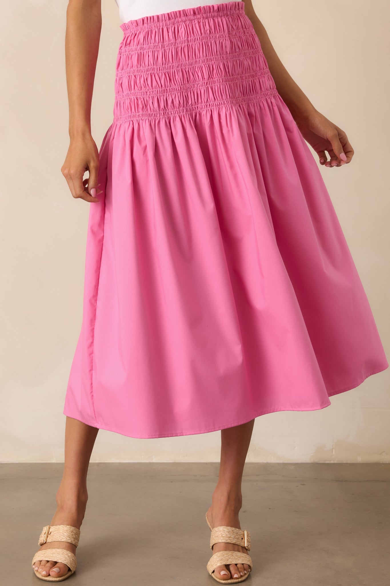 Cropped view of the ruffle trim detail along the flowy pink skirt’s hem.