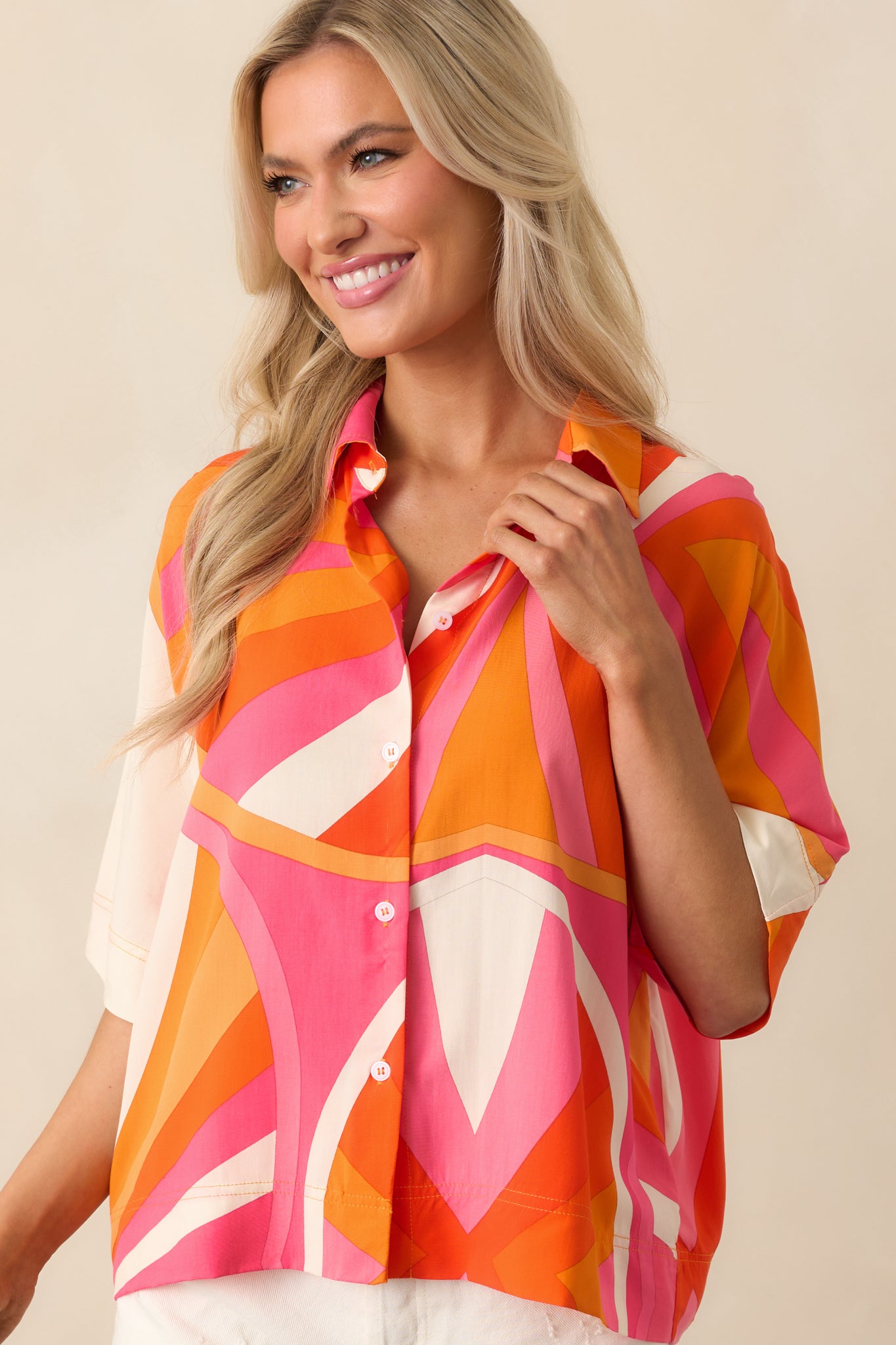Zoomed-in image highlighting the drape and print details of the short-sleeve oversized orange top.