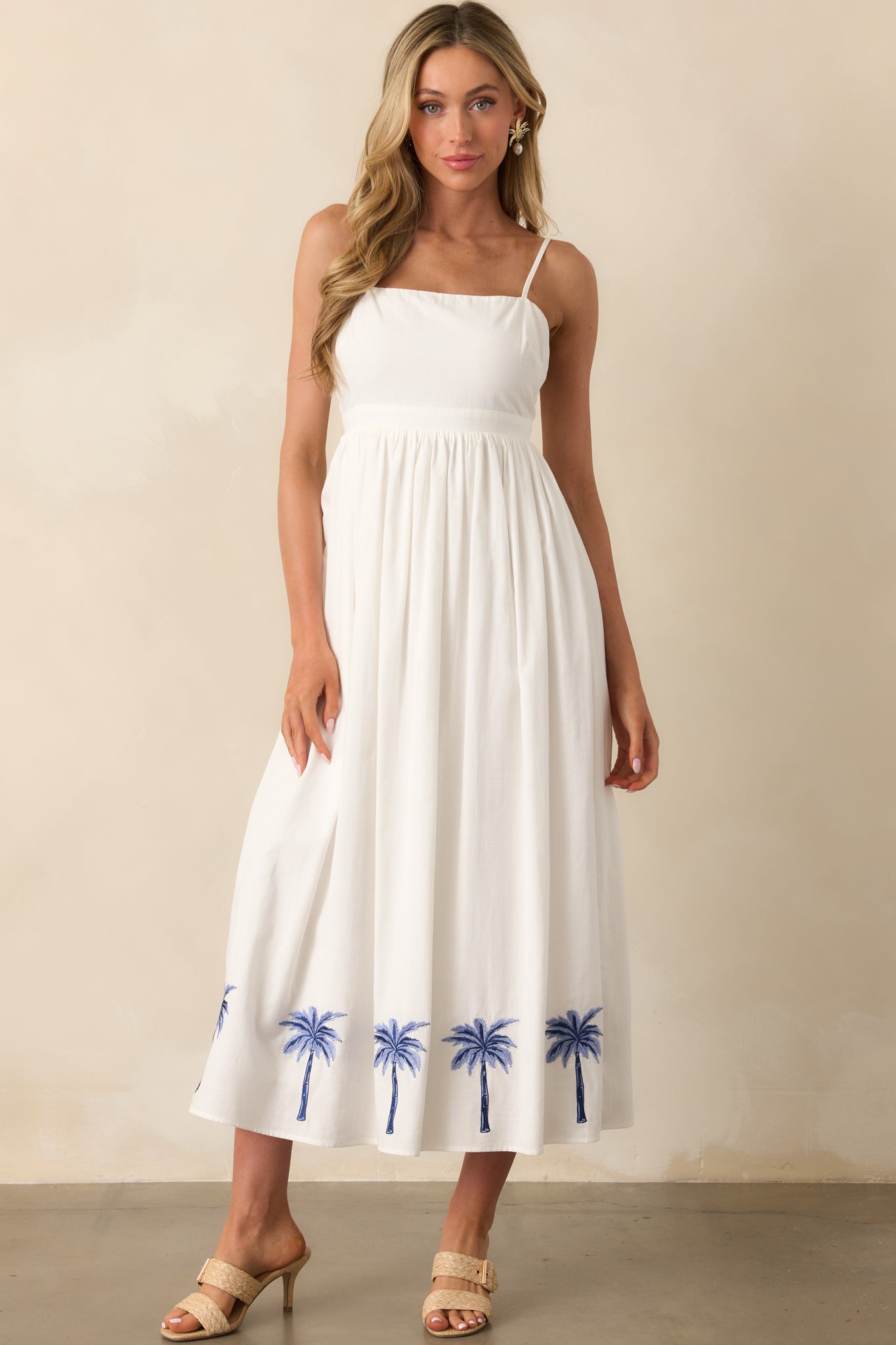 Full-body shot showcasing the embroidered palm print along the bottom hem and the flow of the dress.