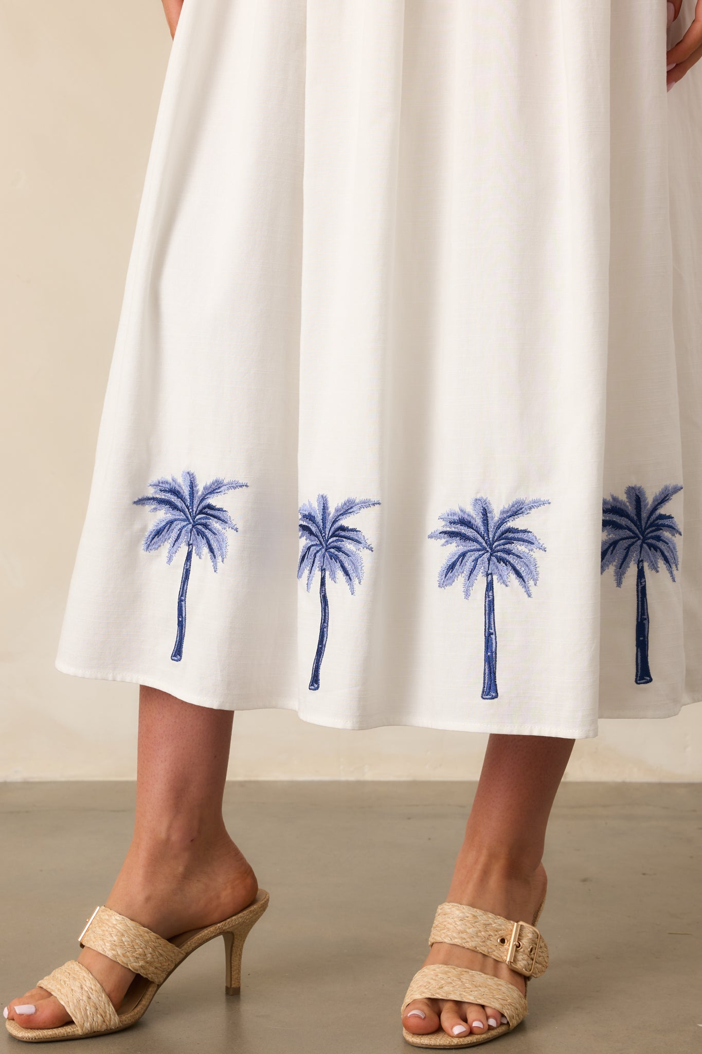 Close-up image focusing on the embroidered palm print along the bottom hem, showcasing the fine stitching and pattern.