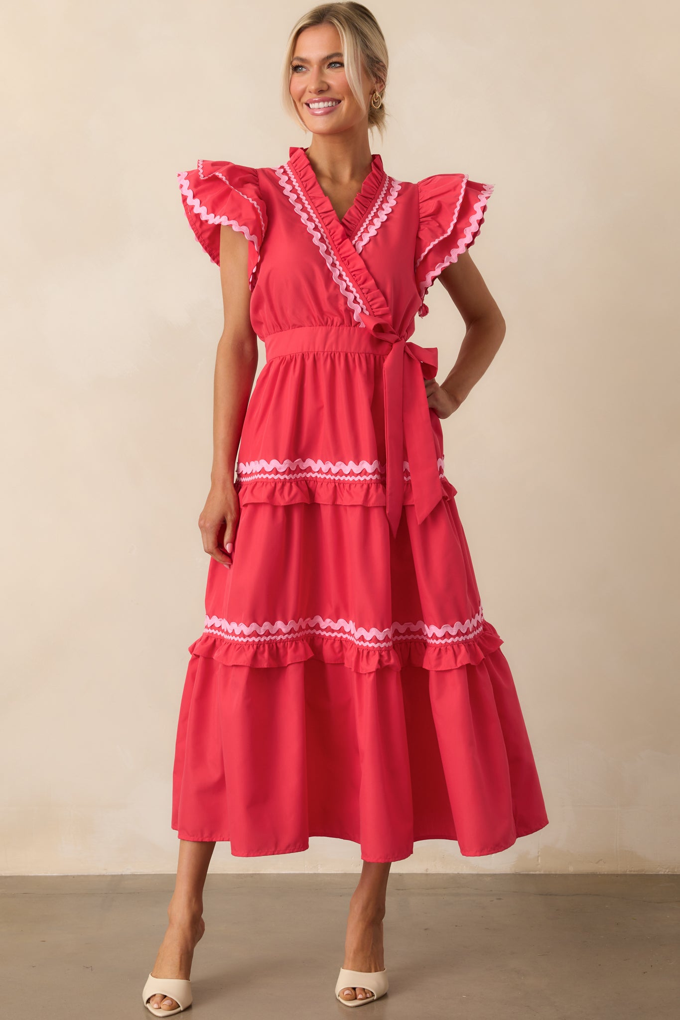 Front-facing look at a red maxi dress with layered ruffles, waist tie, and functional side pockets