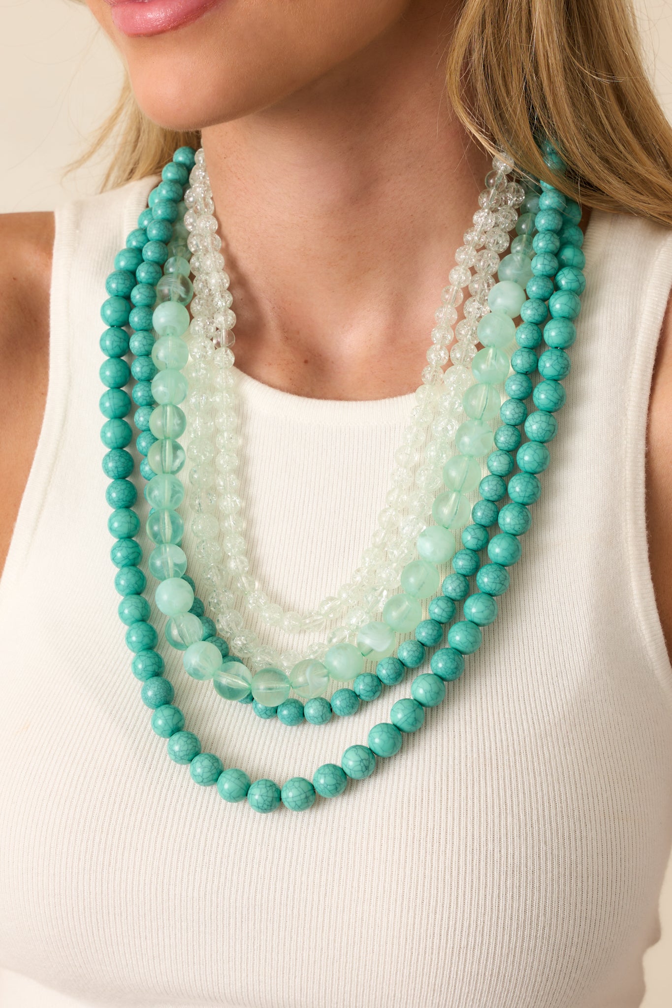 Tightly framed image focusing on the texture and natural variation of the turquoise beads across the layered design.