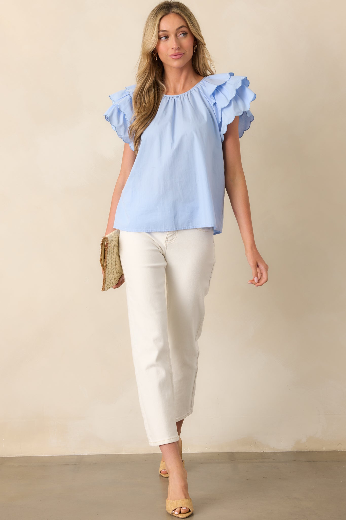 Front-facing full-body image emphasizing the length and drape of the white top with scalloped hems.