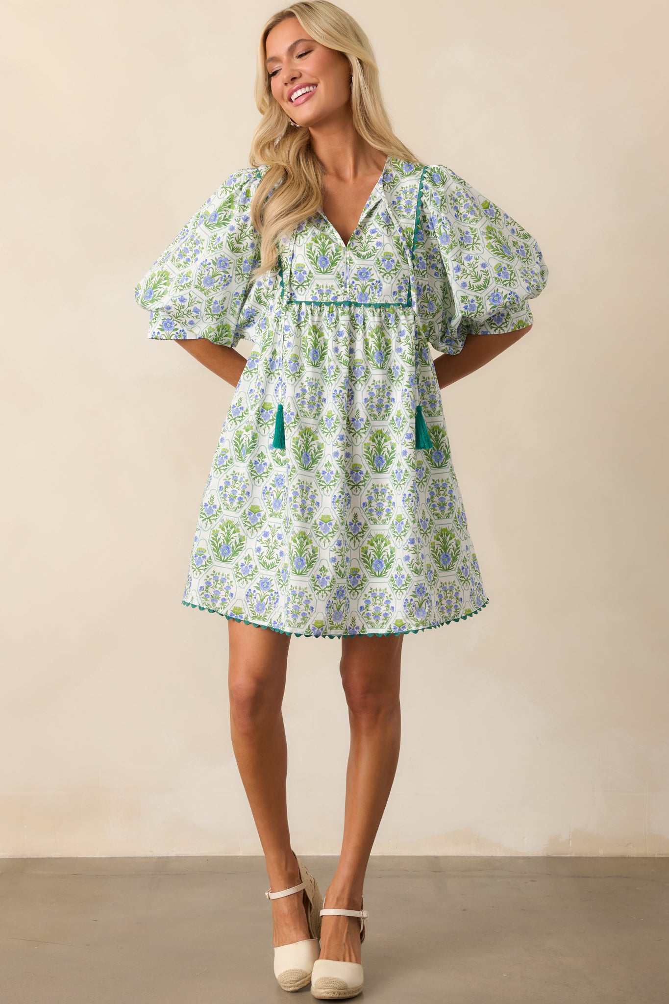 Full length view of the mini dress highlighting its playful pattern, 1/2 length puff sleeves, and functional pockets.