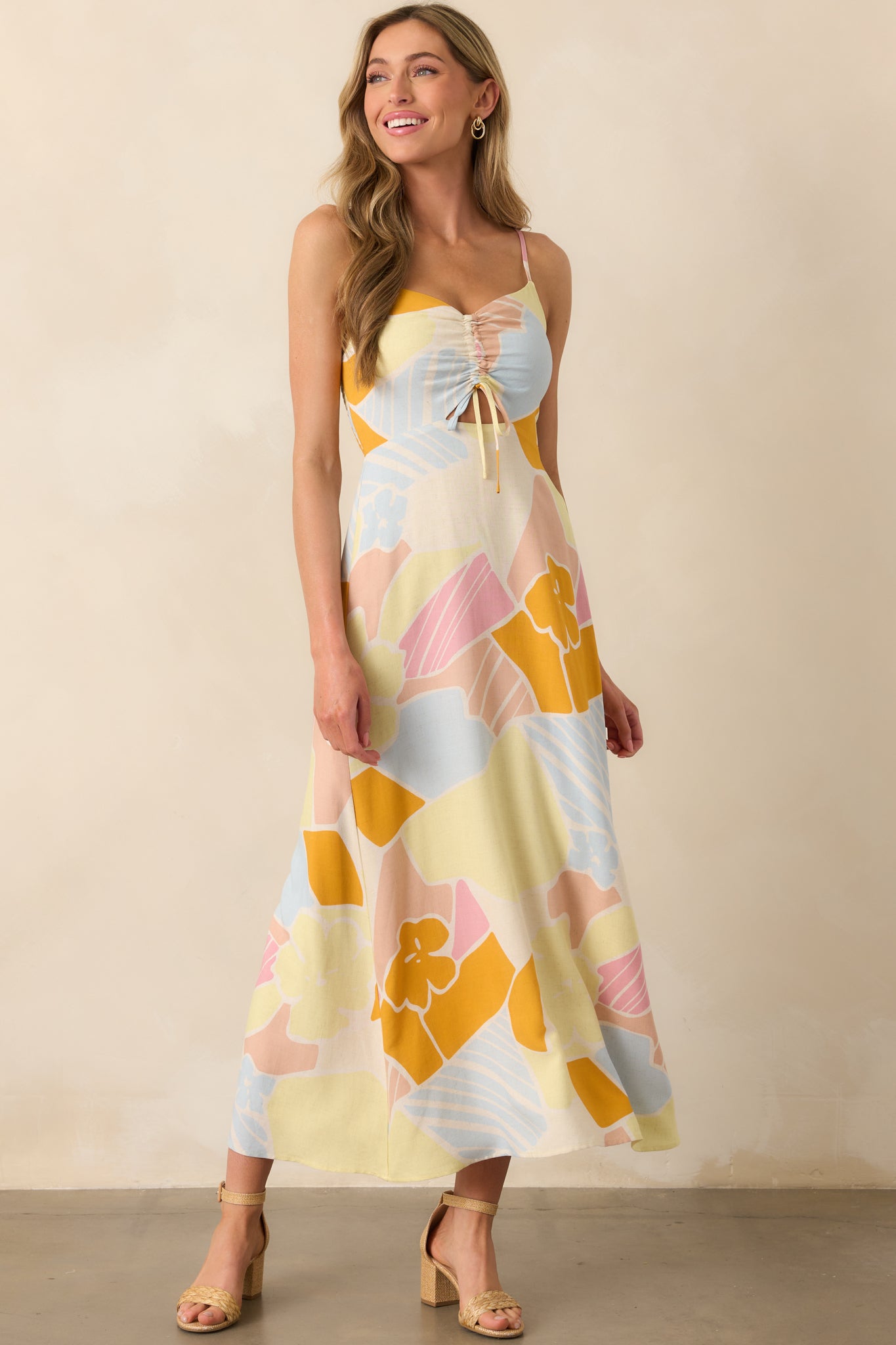Mellow yellow maxi dress with a v-neckline and cutout detail under the bust, shown in a full body front view with a flowy silhouette.