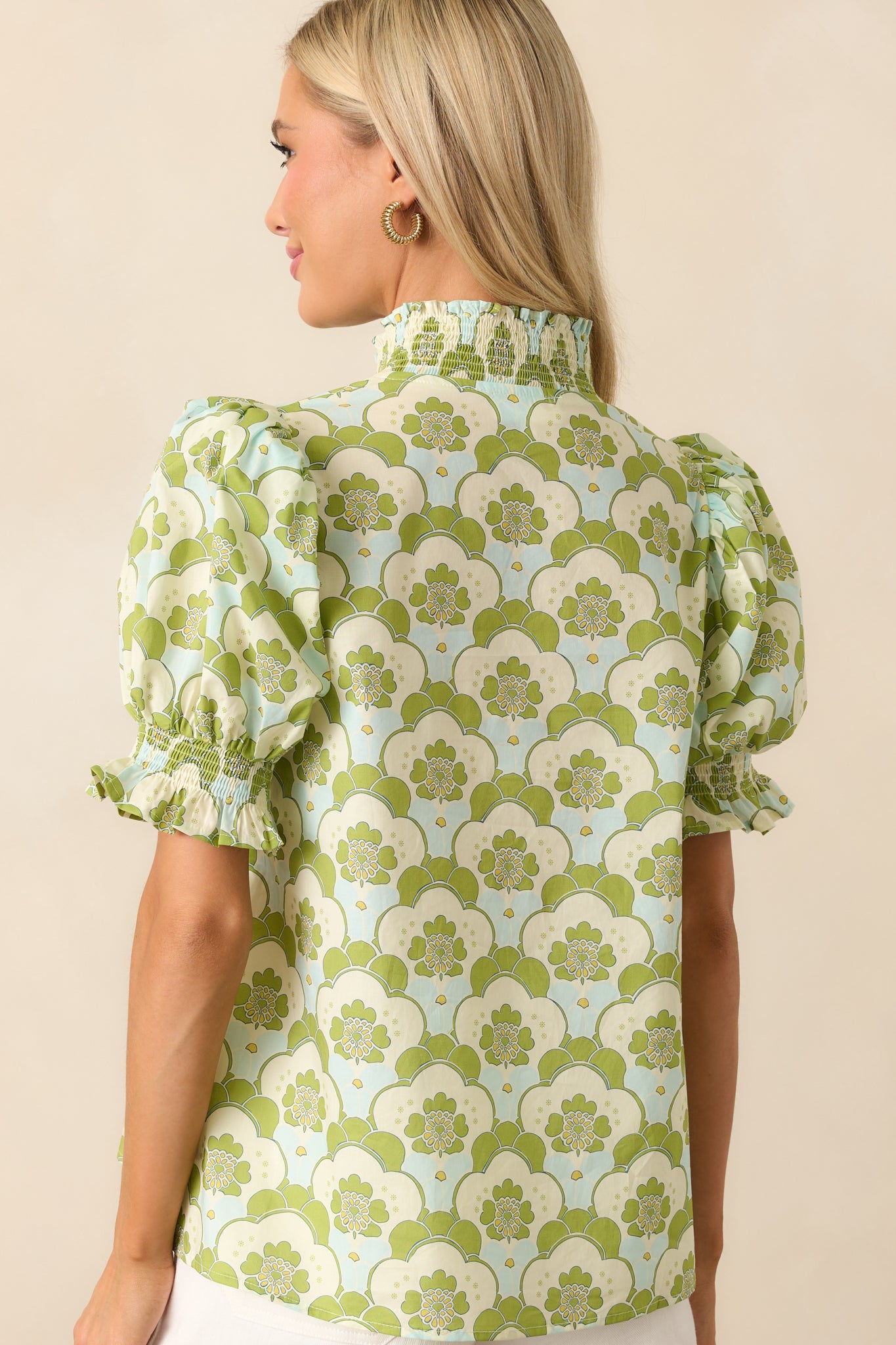 Back view of the printed top revealing the full floral pattern and soft draping around the smocked neckline.