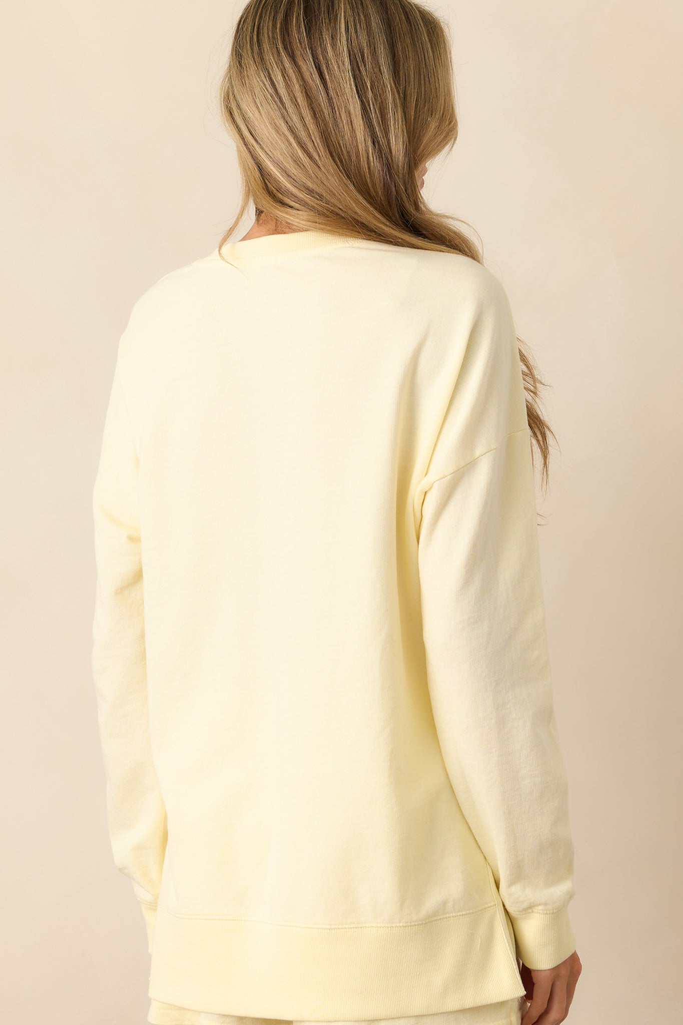 A view from behind of the mellow yellow sweatshirt, displaying its oversized fit and clean back panel.