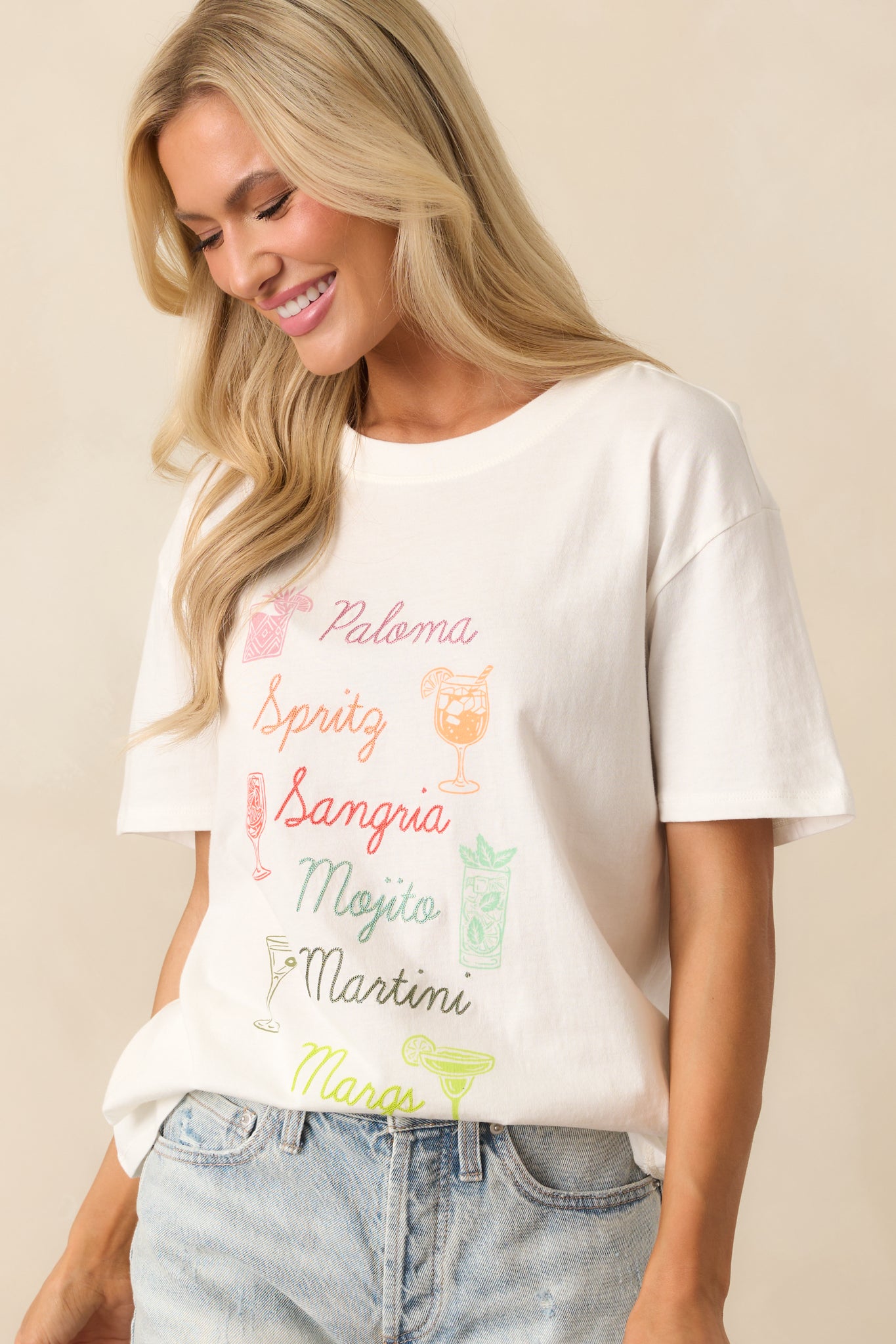 Zoomed-in photo of the tee’s chest area featuring a mix of text embroidery and vibrant cocktail illustrations.