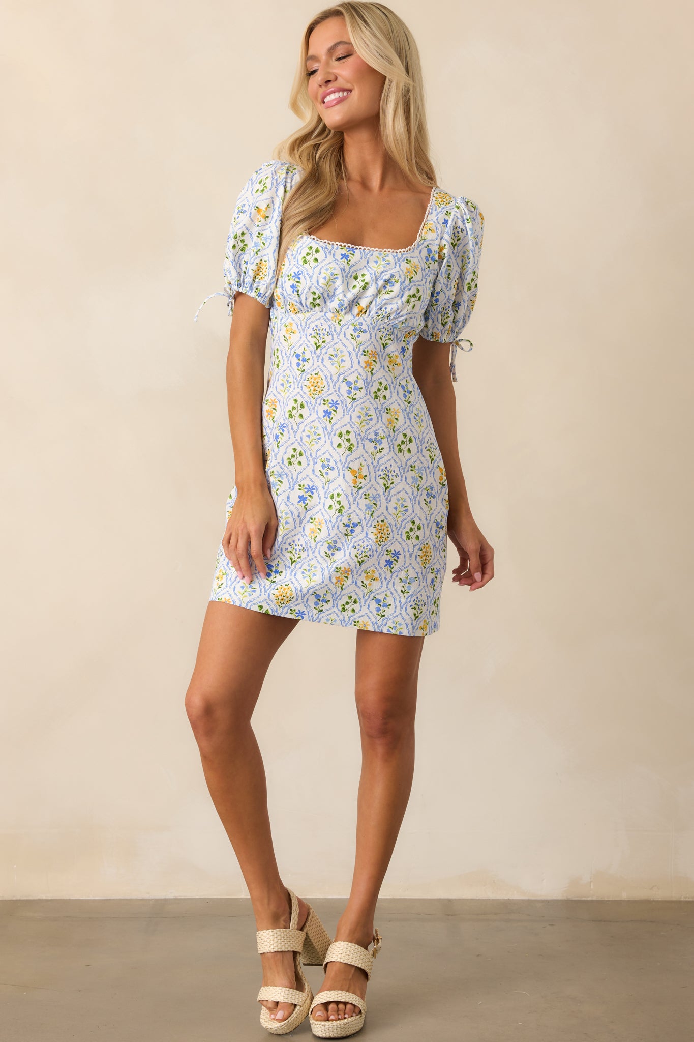 Full-length shot of floral mini dress showcasing puff sleeves with self-tie detail and a breezy cotton silhouette.
