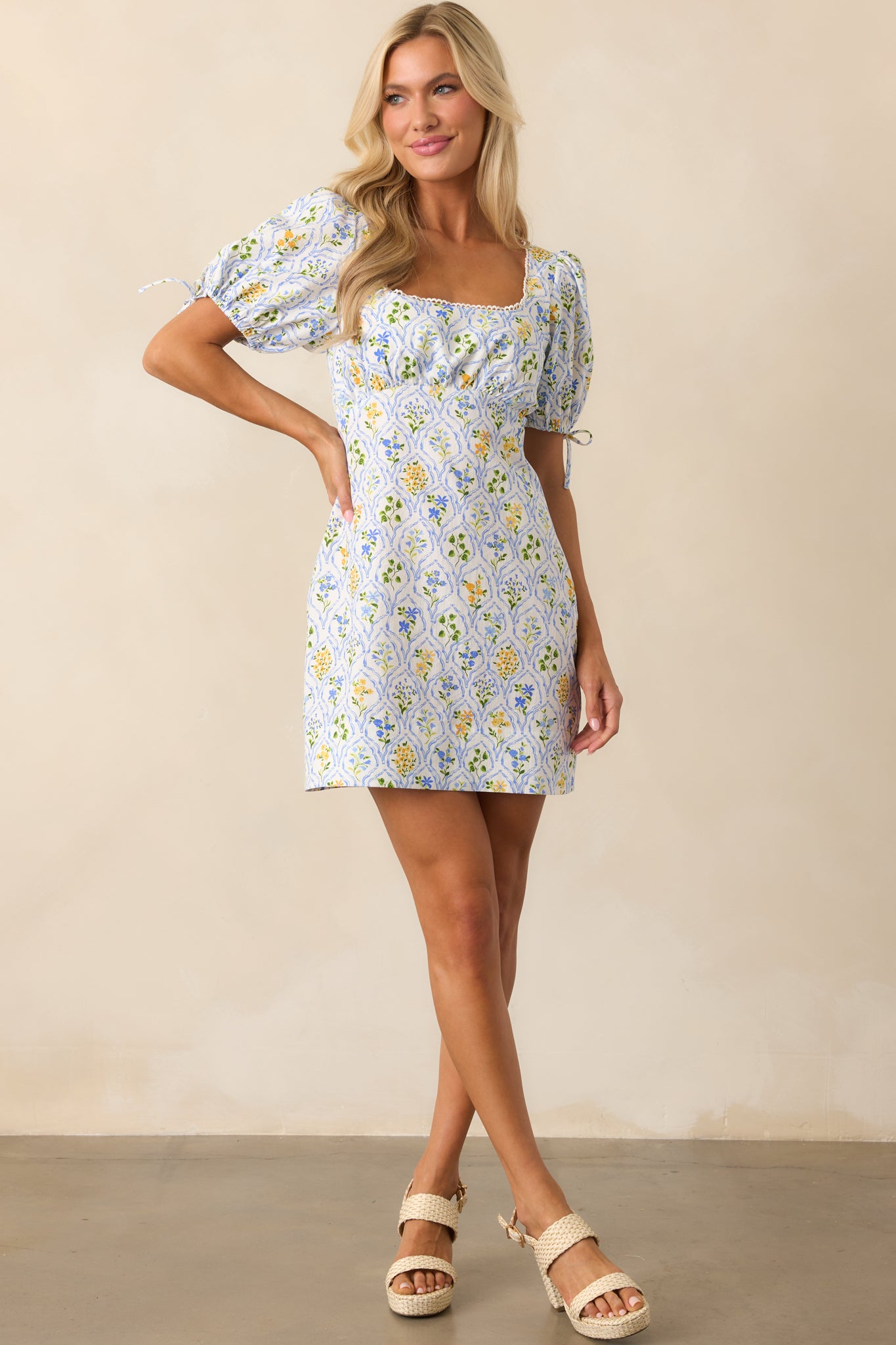 Front-facing view of mini dress highlighting the floral print, scalloped square neckline, and soft structure of 100% cotton fabric.