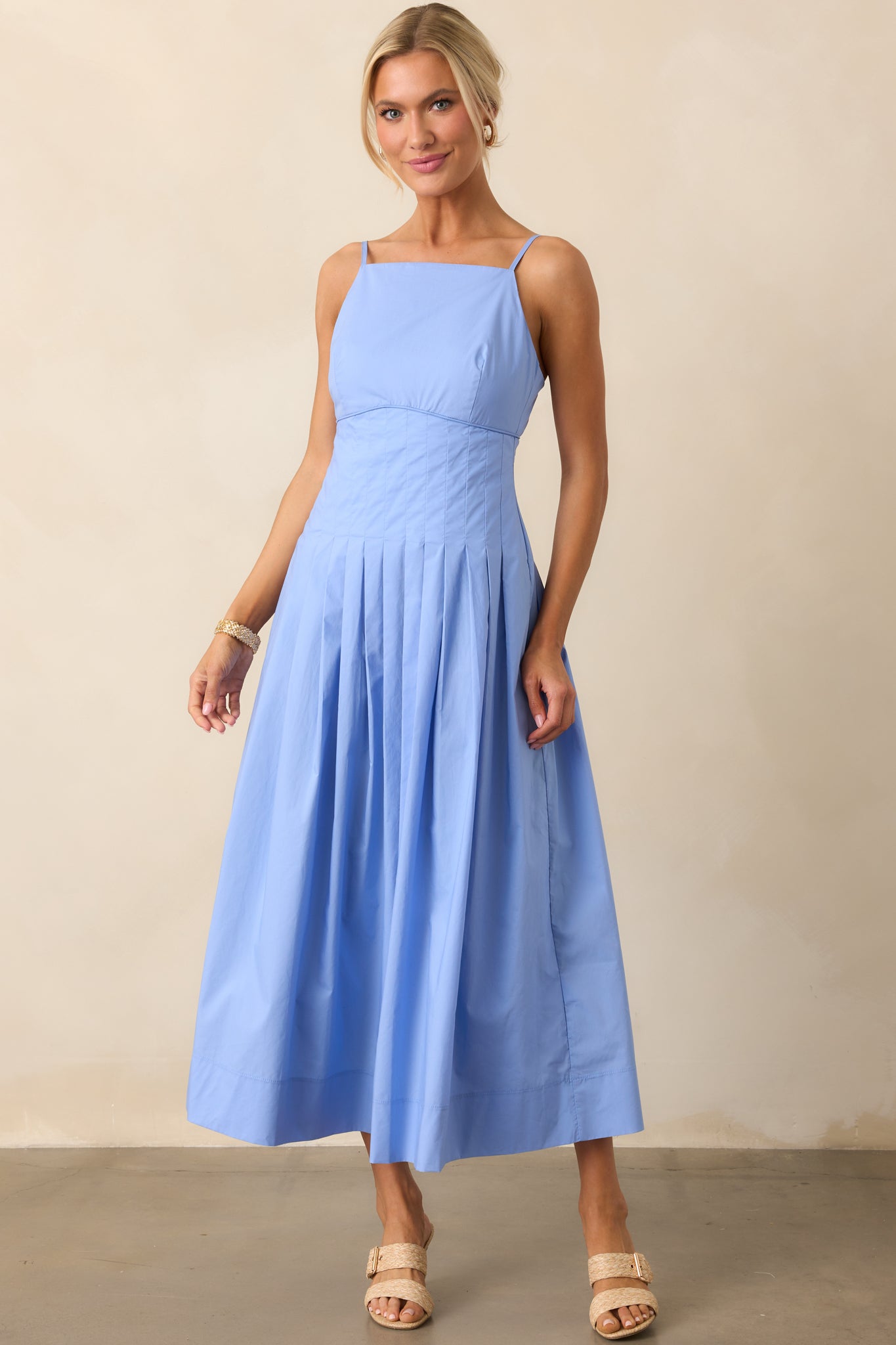 Front angle of the jacaranda blue midi dress highlighting the fitted bodice, apron neckline, and lightweight cotton texture.