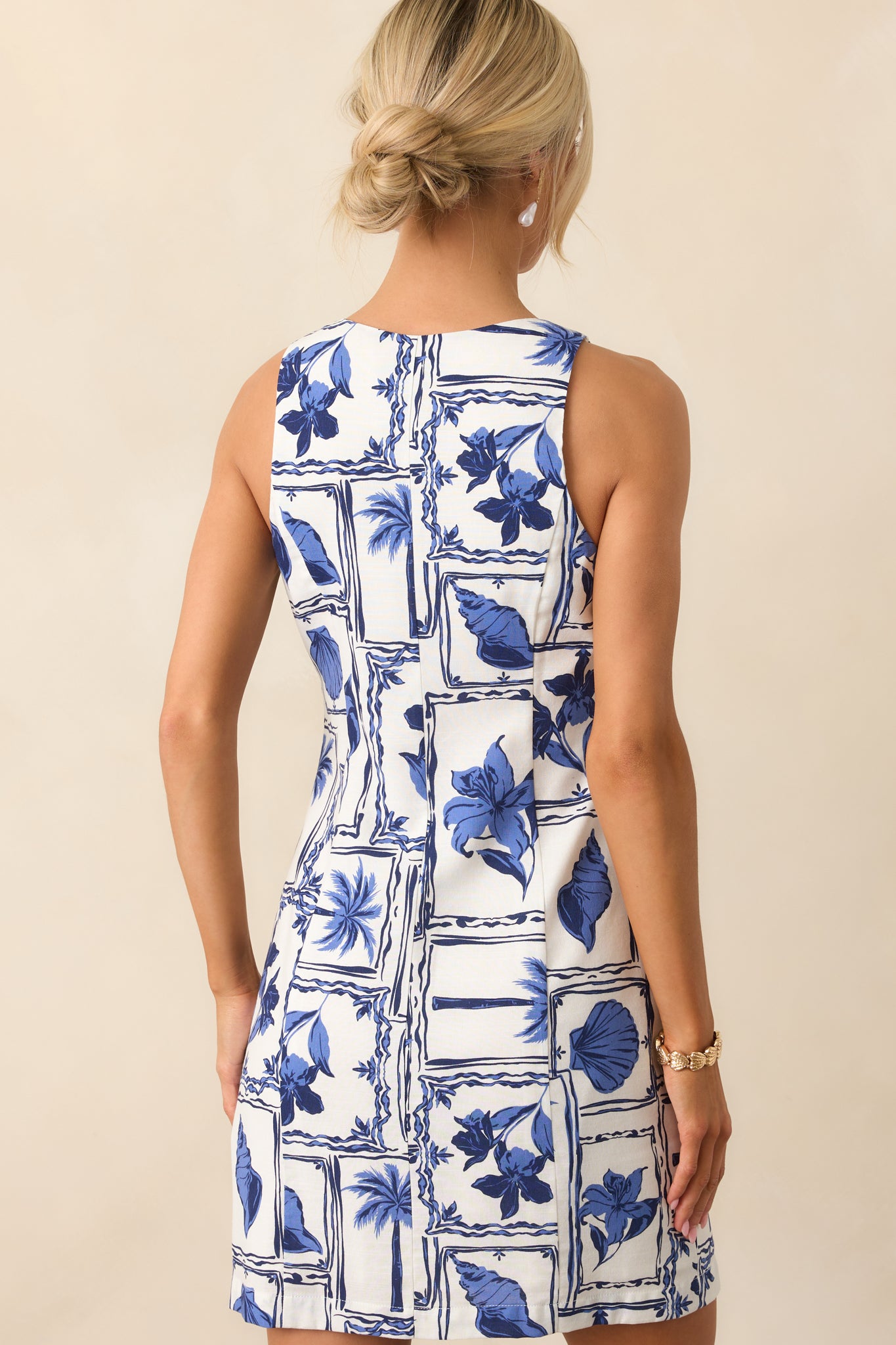 A view from behind showing the continuation of the patchwork print and the sleeveless mini dress silhouette.