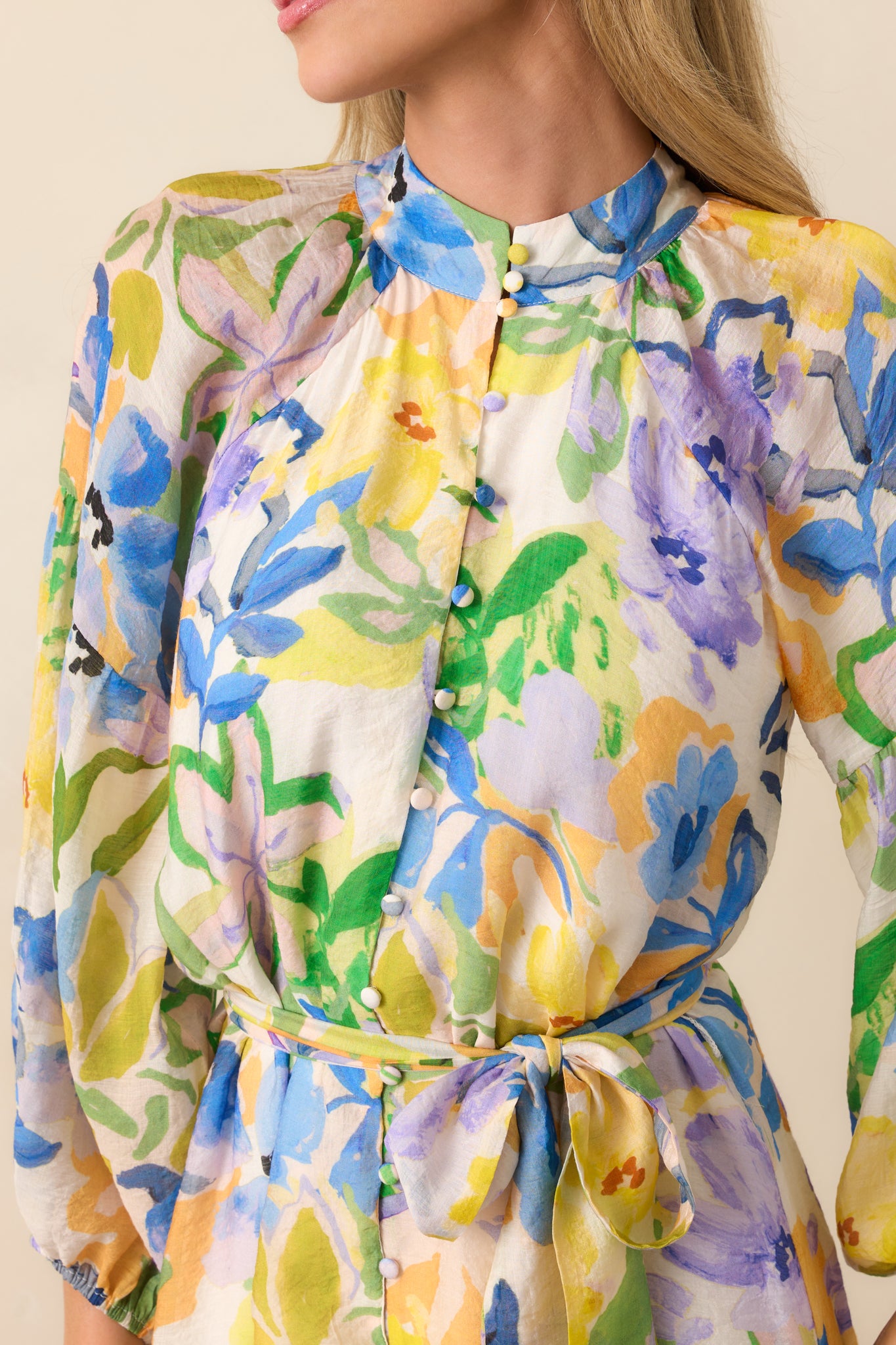 Close-up of the floral print fabric and functional button front, showing texture and pattern details.