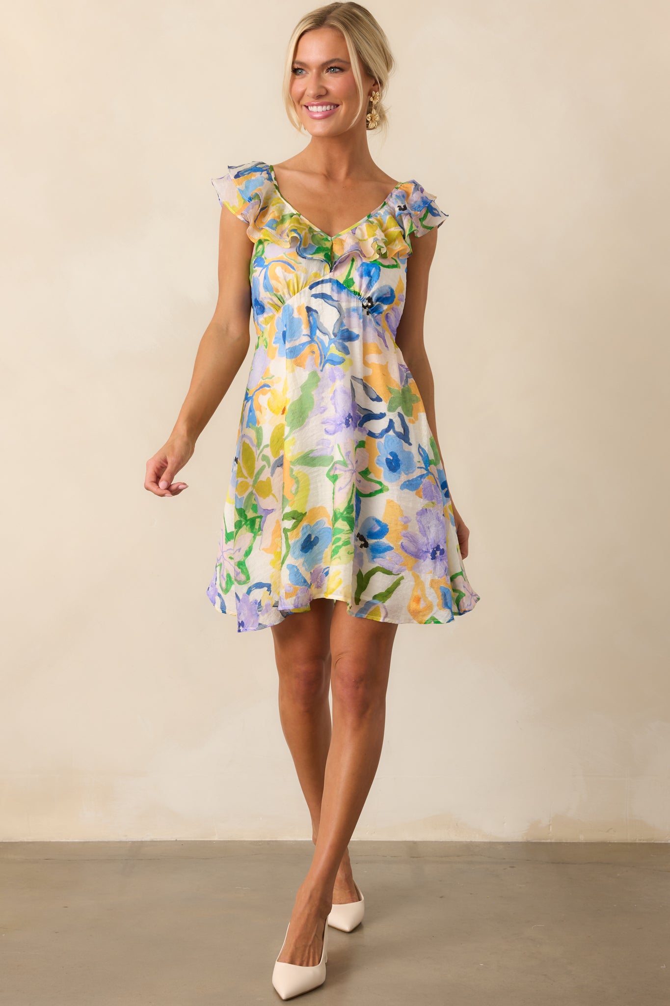 Full-length shot of floral mini dress highlighting the vivid pattern, mini hemline, and soft structure.