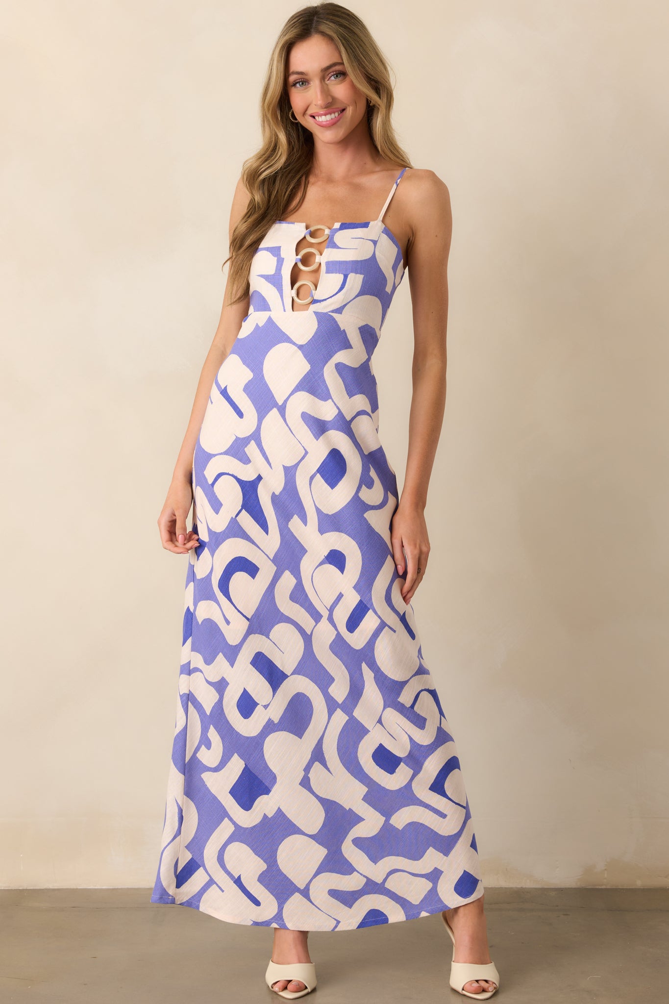 Full body shot of the midi dress, displaying the vibrant geometric print and unique cutout design along the bodice.