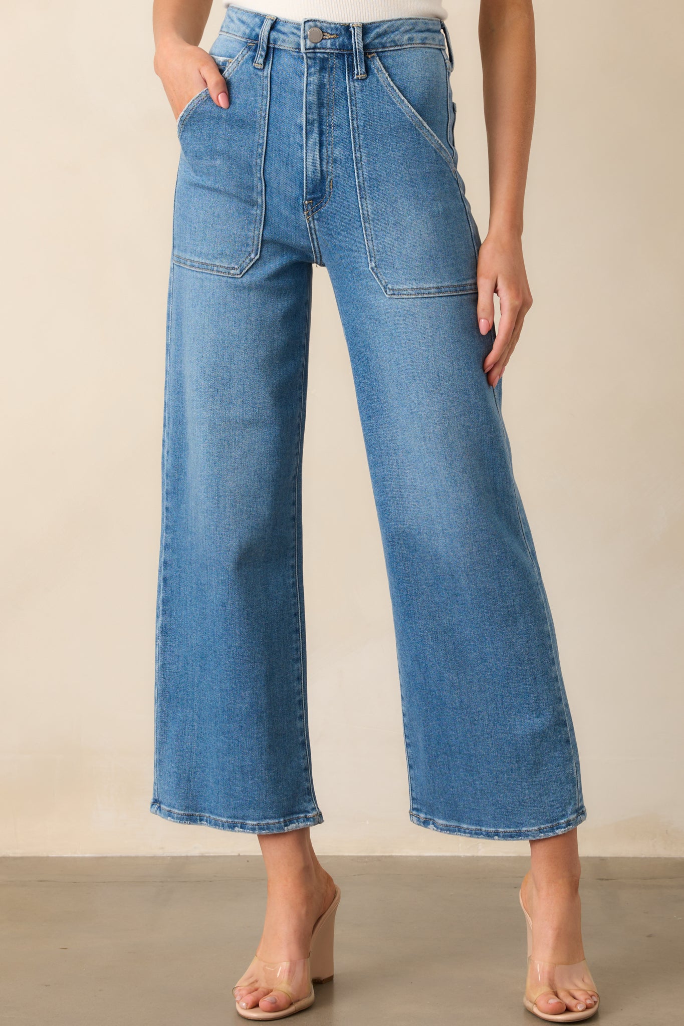 Detailed view of the upper thigh area, emphasizing texture and pocket stitching on the jeans.