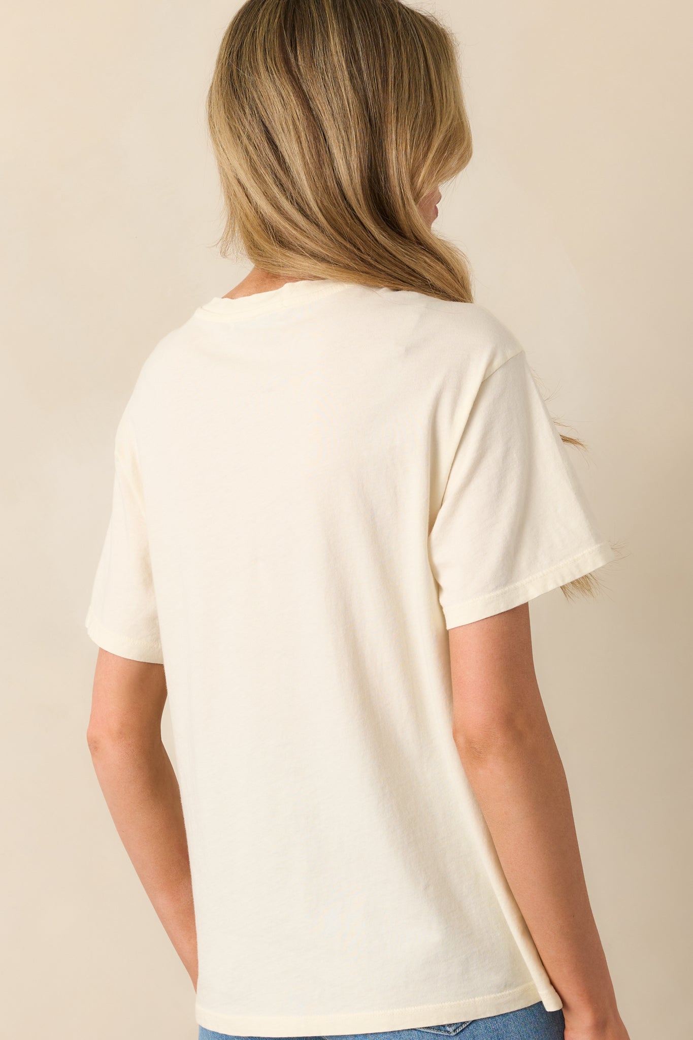 A back view of the tee displaying the plain fabric and relaxed fit from behind, with a soft drape and short sleeves.