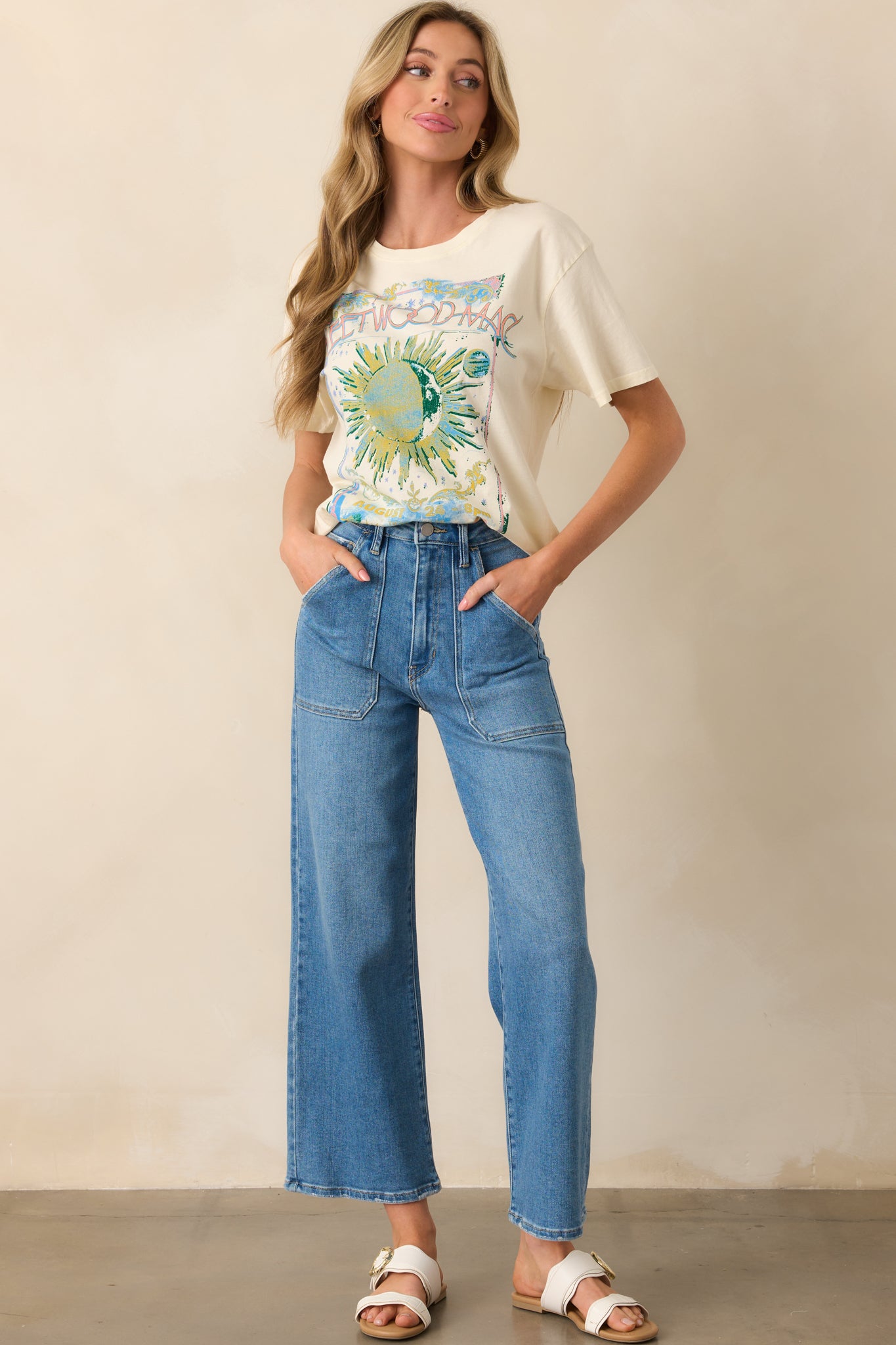 A full body image showcasing a short-sleeve tee with vintage-style Fleetwood Mac poster art and a loose, casual silhouette.