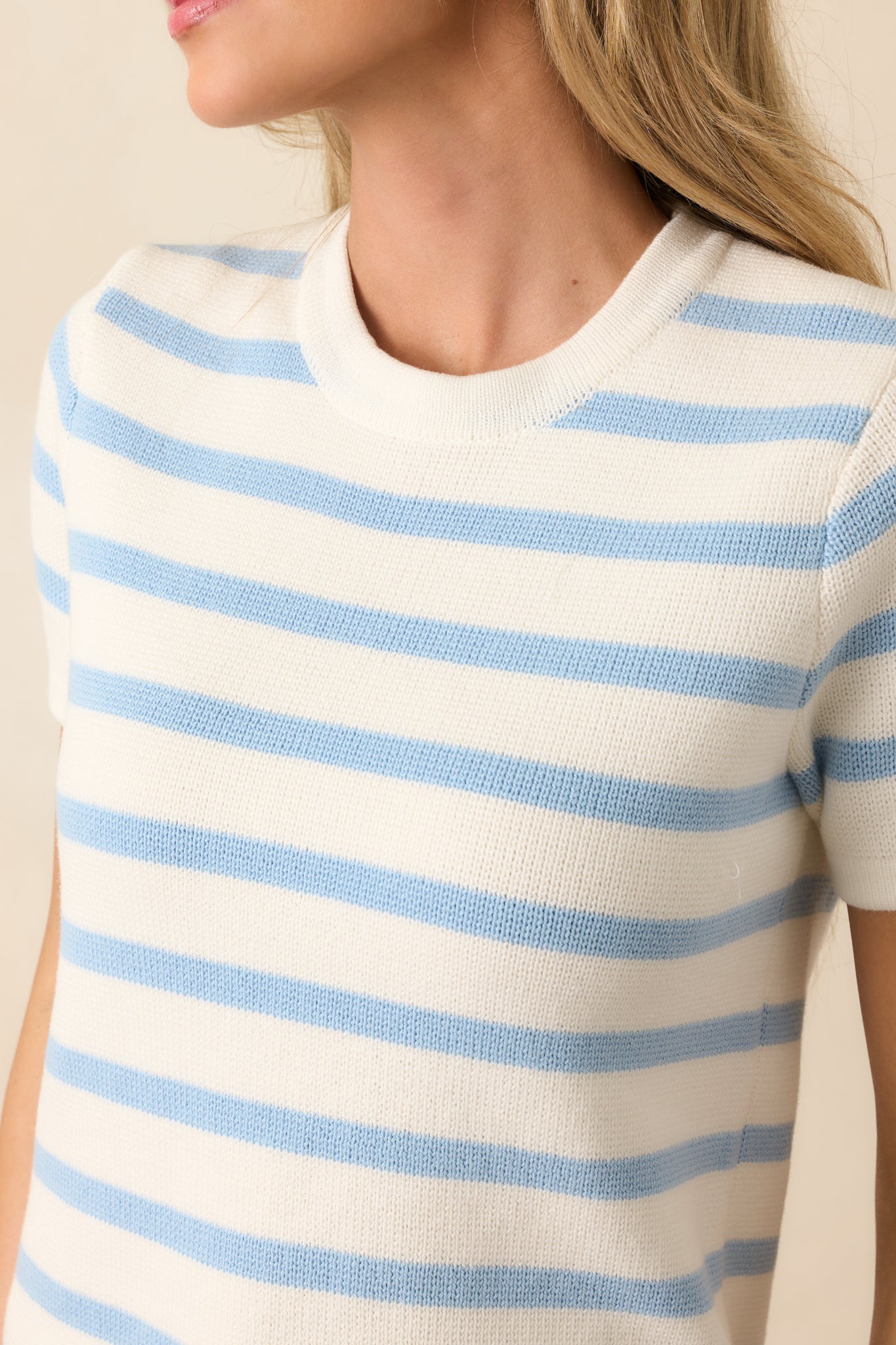 An extreme close-up of the sweater’s knit texture, showing the sharp contrast between blue and ivory stripes.