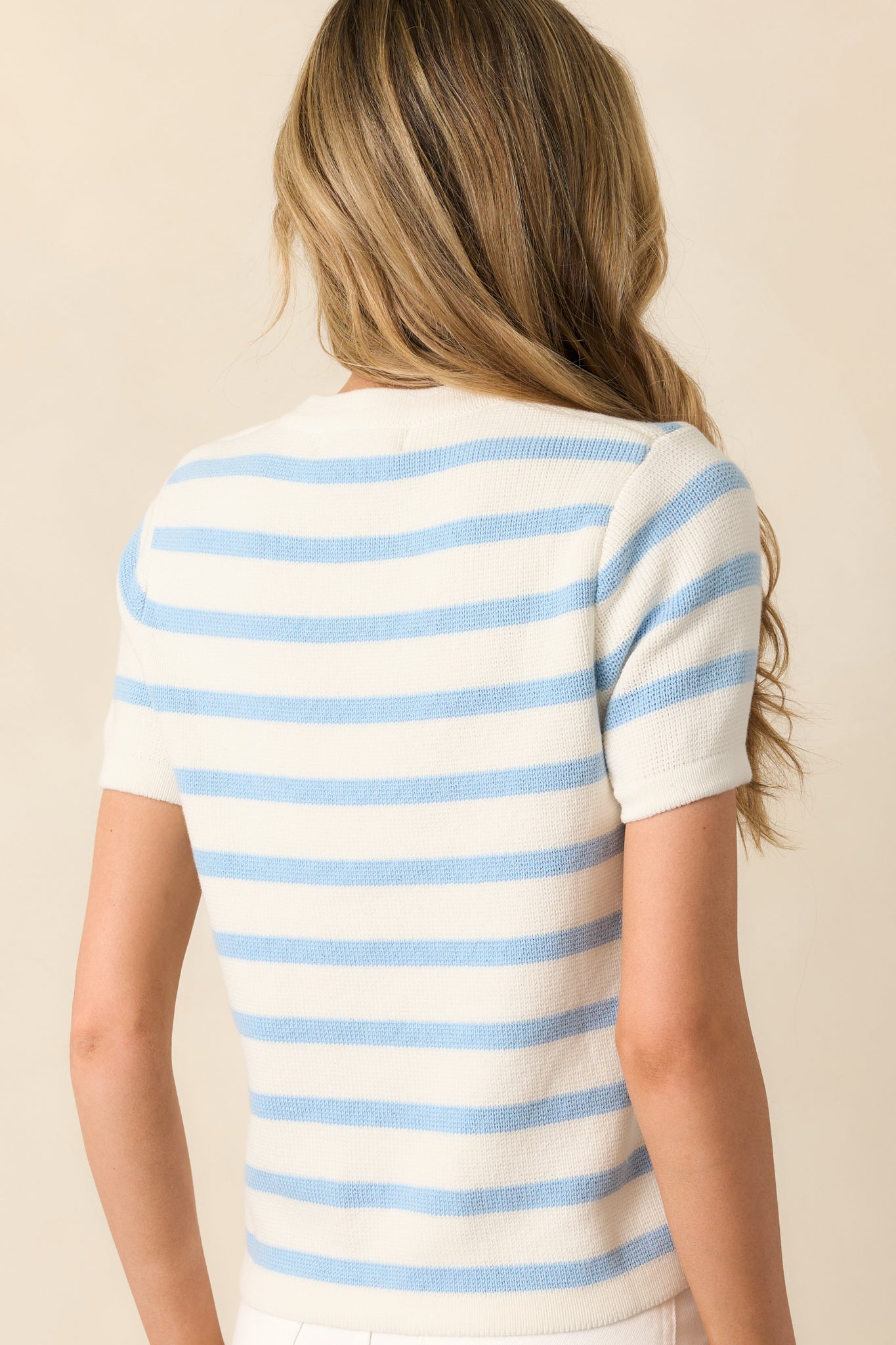 A back view of the green and ivory striped sweater, showing the even stripe placement and relaxed fit through the back.