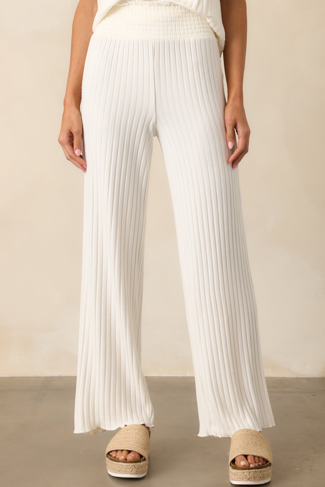 A close-up of the pants' hemline showing the textured ribbed fabric and the wavy lettuce trim along the edge.