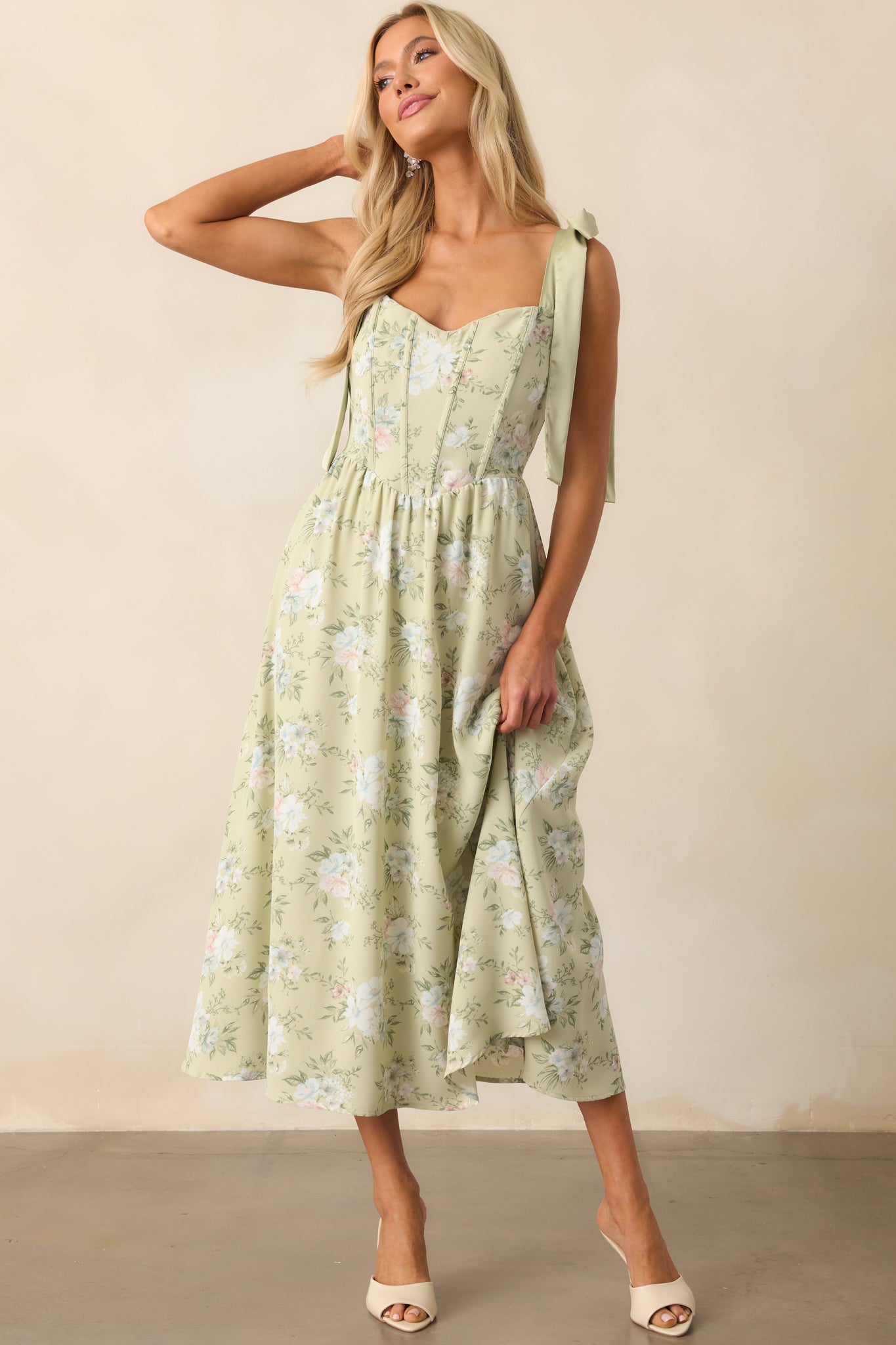 Front-facing view of the light sage dress highlighting the scoop neckline and subtle contrast of green straps.