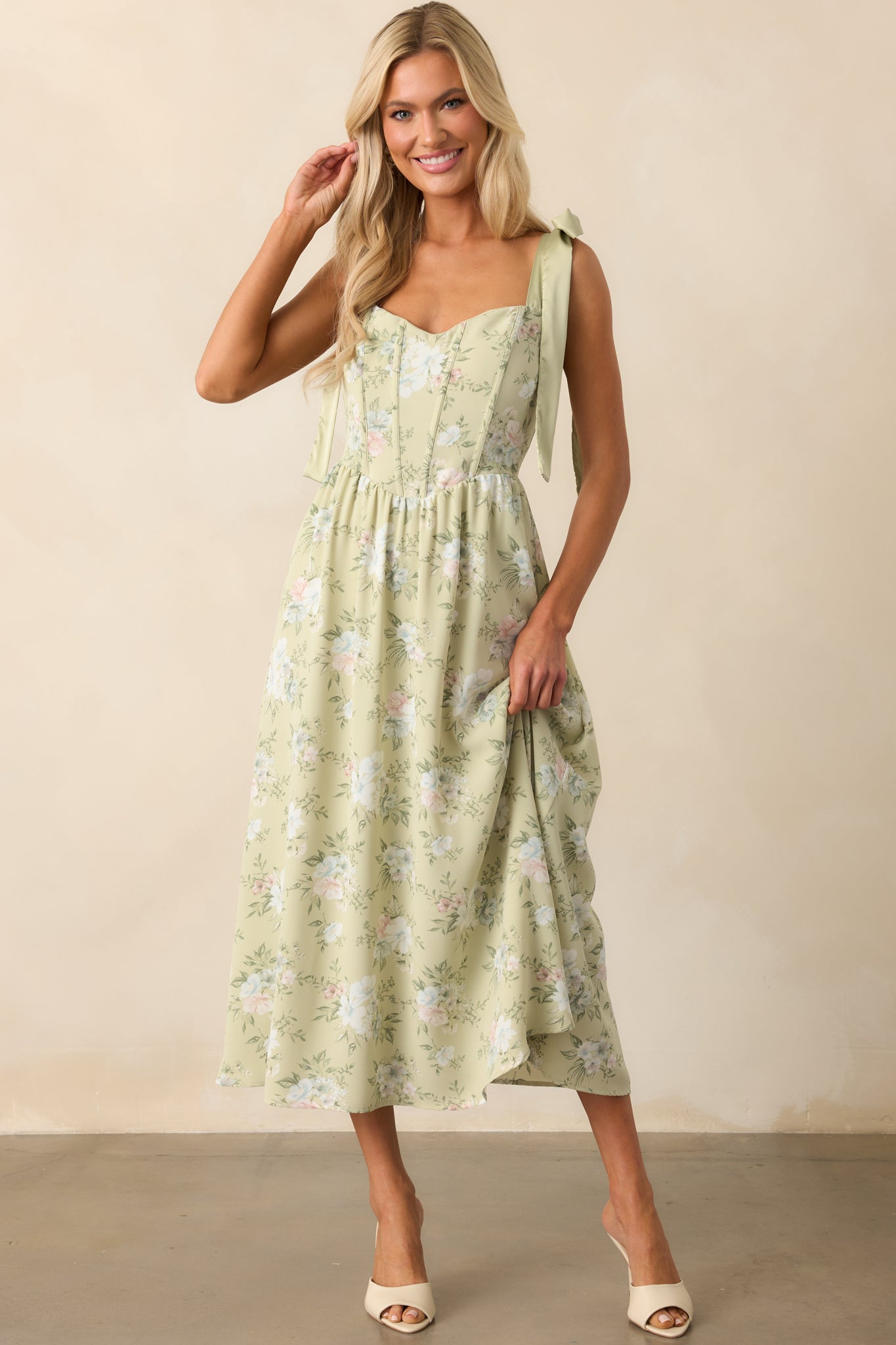 Full-length image emphasizing the elegant combination of chiffon layers and structured bodice in the sage dress.