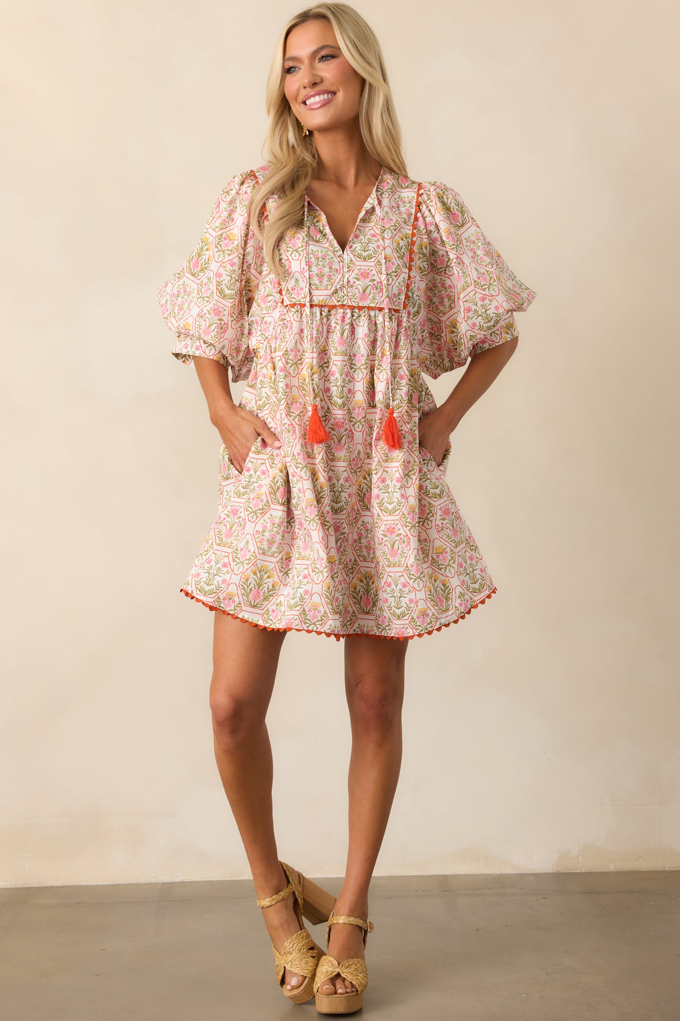 Mini dress with bold orange ric rac trim, functional pockets, and a vibrant floral and geometric pattern.