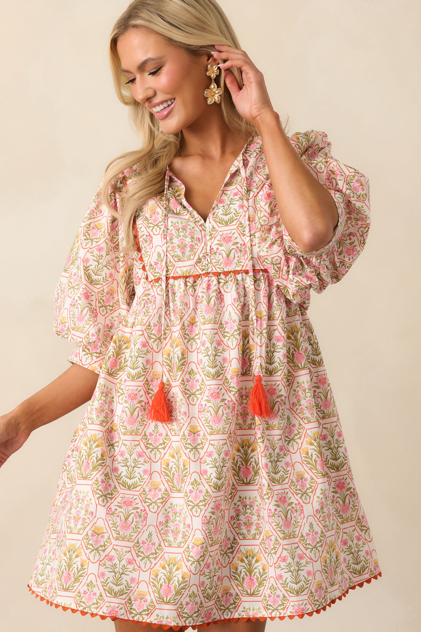 Detailed view of puff sleeve with orange ric rac trim and colorful motif on the mini dress fabric.