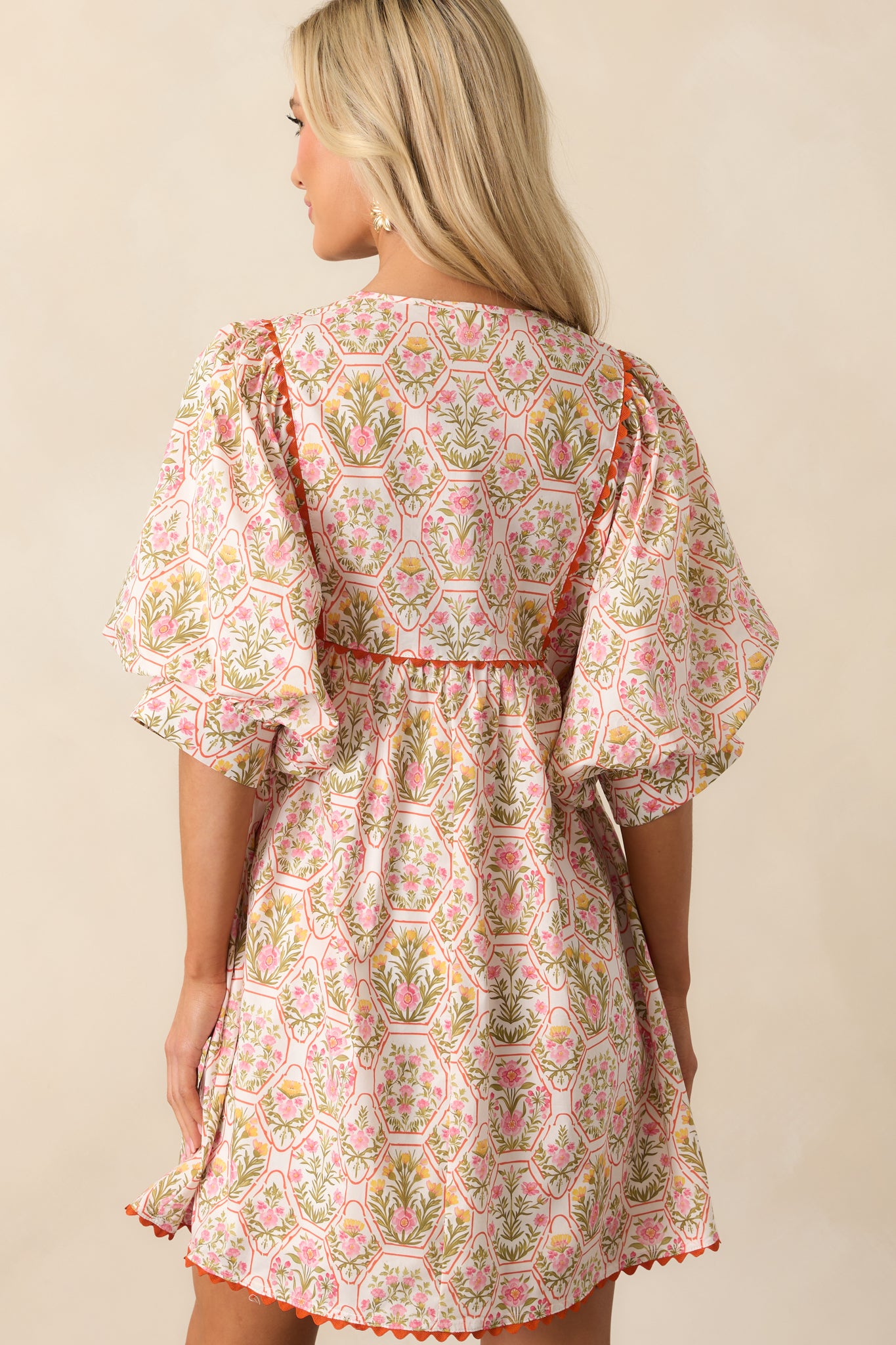 A view from behind showing the full print pattern, puff sleeves, and relaxed shape of the mini dress.