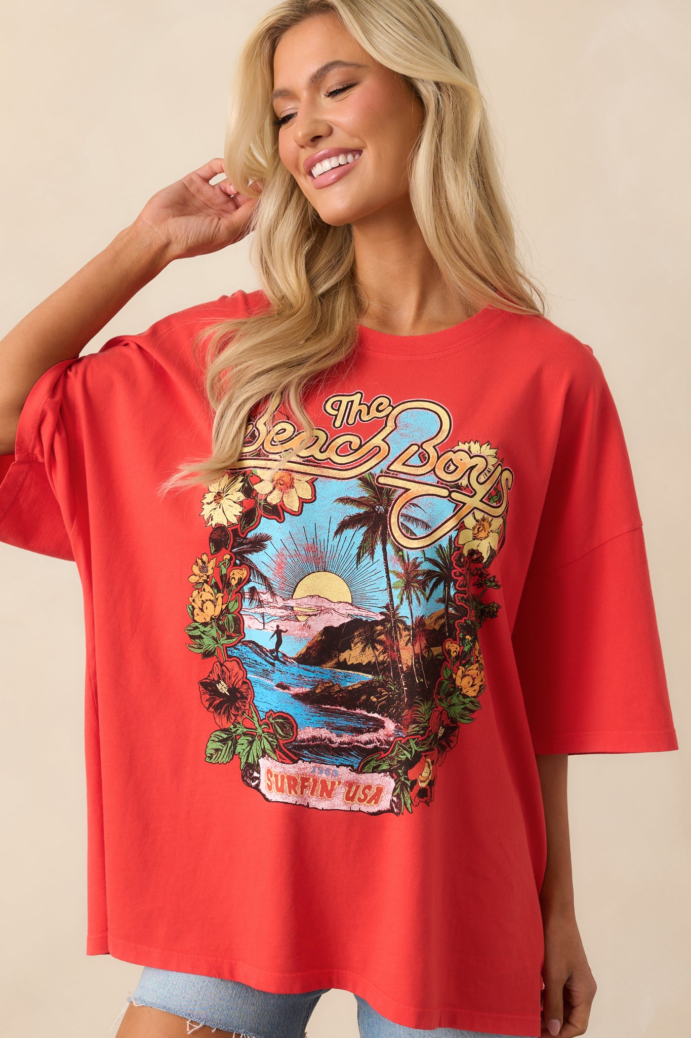 Focused view on the midsection of the red tee, capturing the oversized drape and hemline details