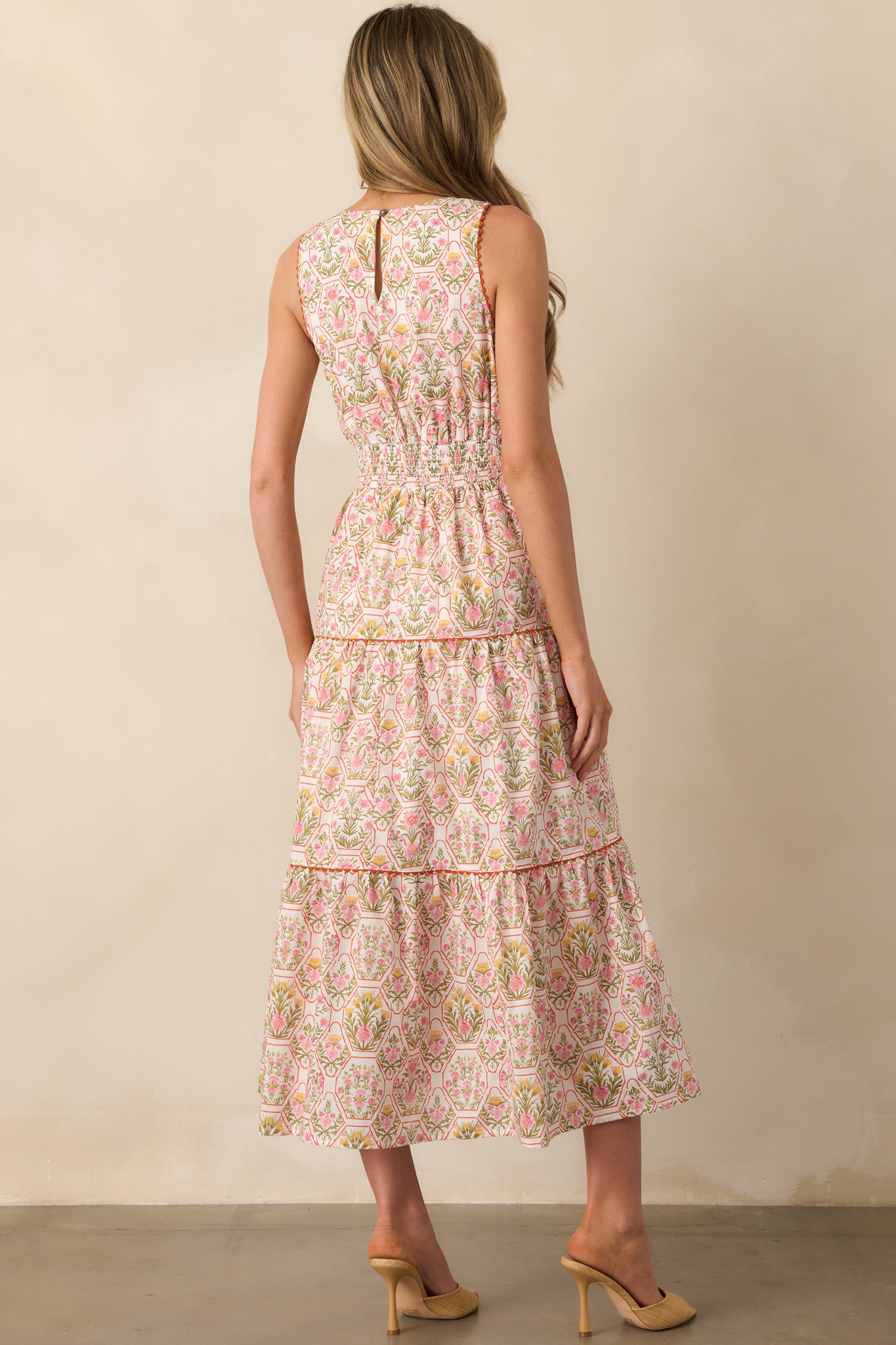 A view from behind showing the keyhole closure, smocked waist panel, and continuation of the geometric and floral design.